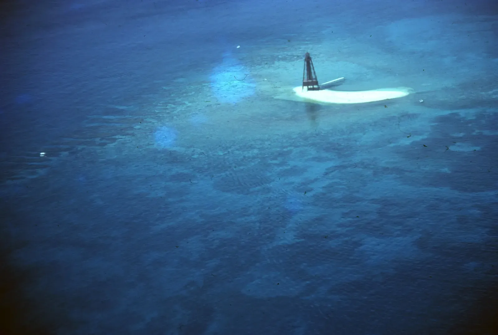 Aerial view of Sand Key Lighthouse surrounded by the reef and open water