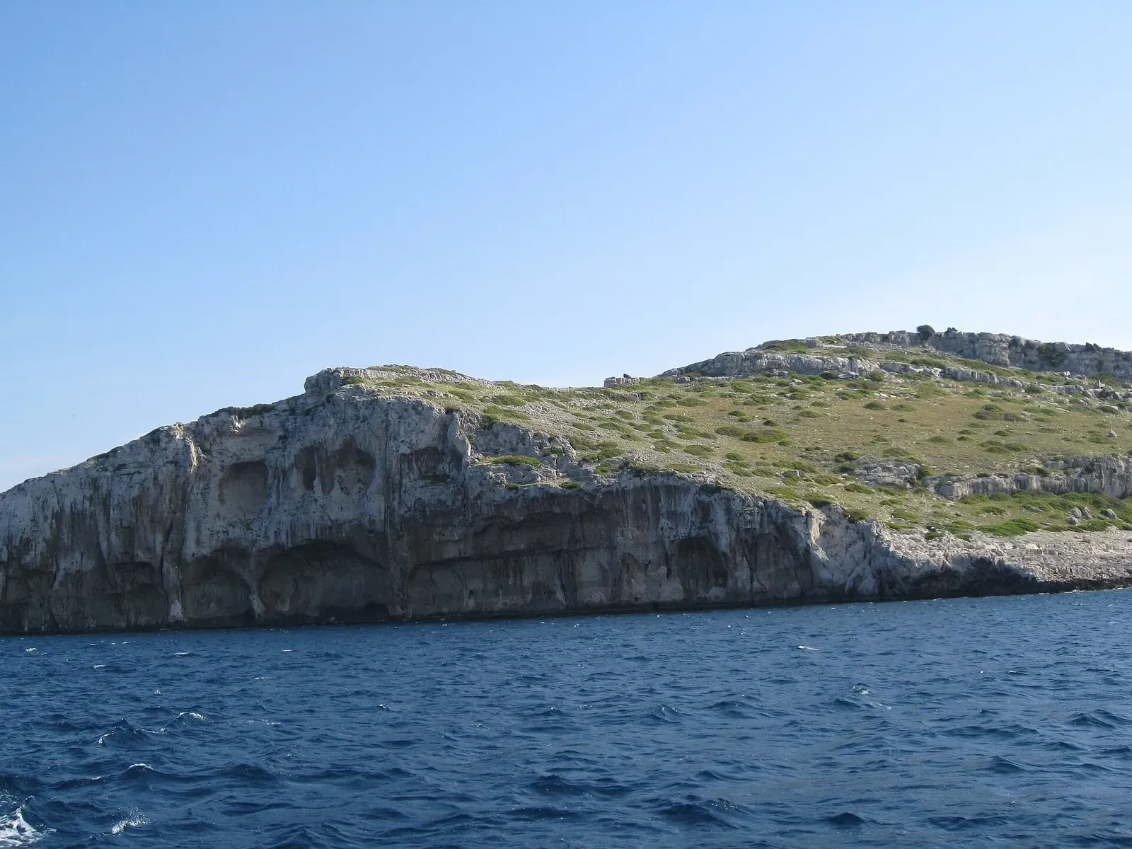 Balun island's low rocky profile seen from a boat on the open Adriatic — Kornati Islands.