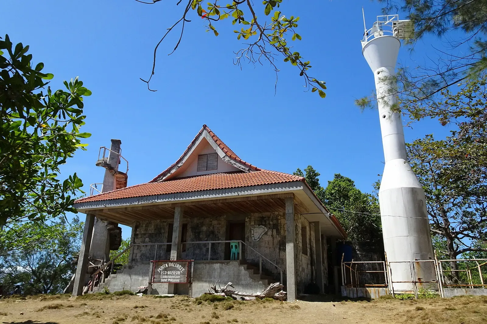The white lighthouse tower standing above buildings on Cabilao Island