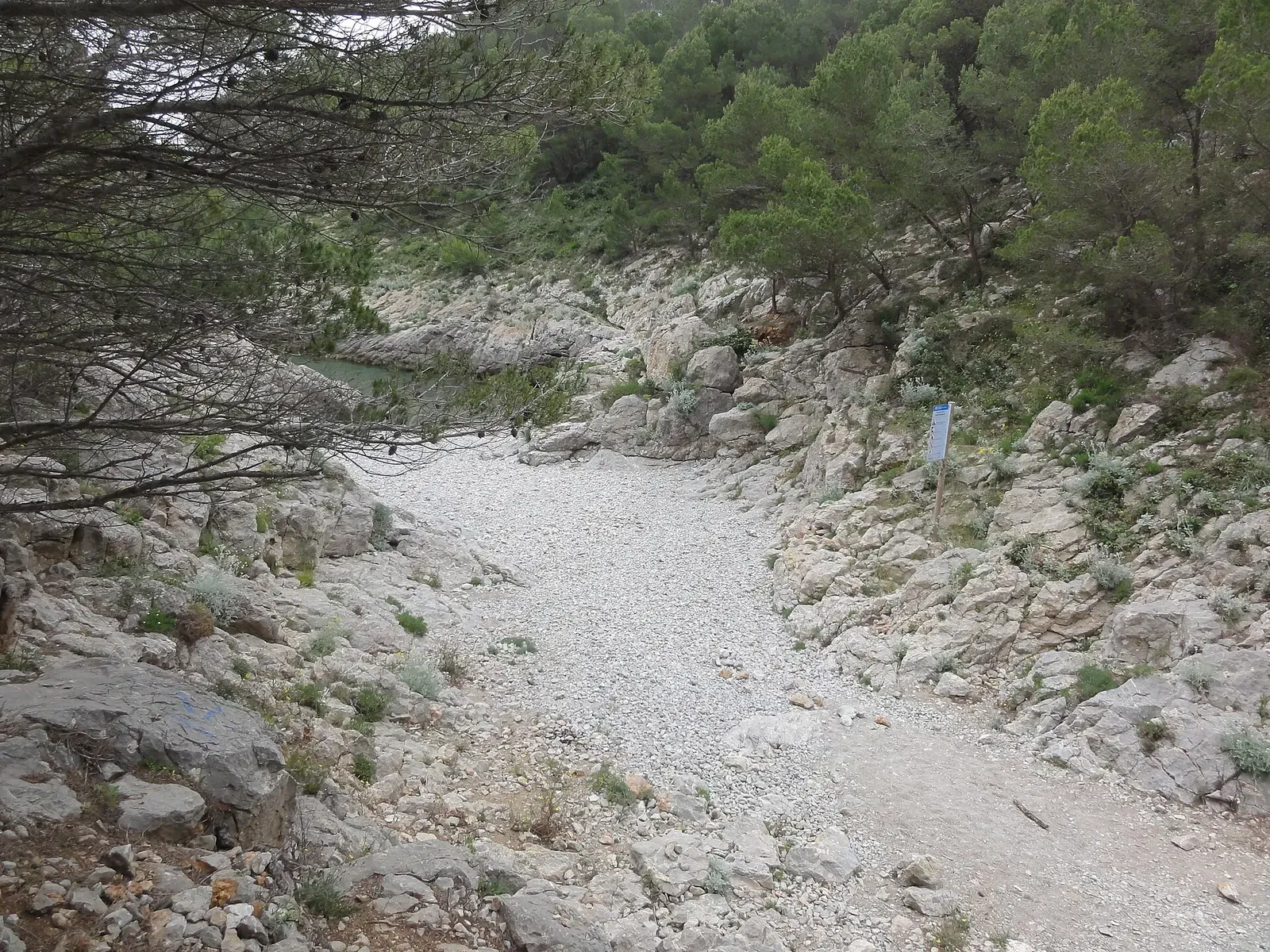 Pebble cove of Cala Pedrosa between orange cliffs on the Montgrí massif