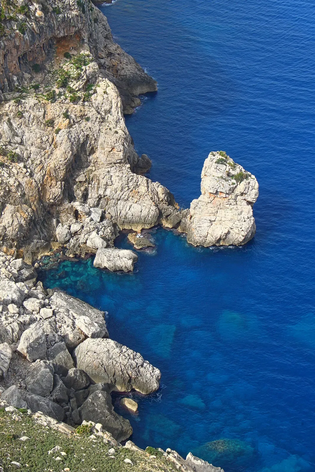 Rocky islet in turquoise water below the Mirador es Colomer viewpoint