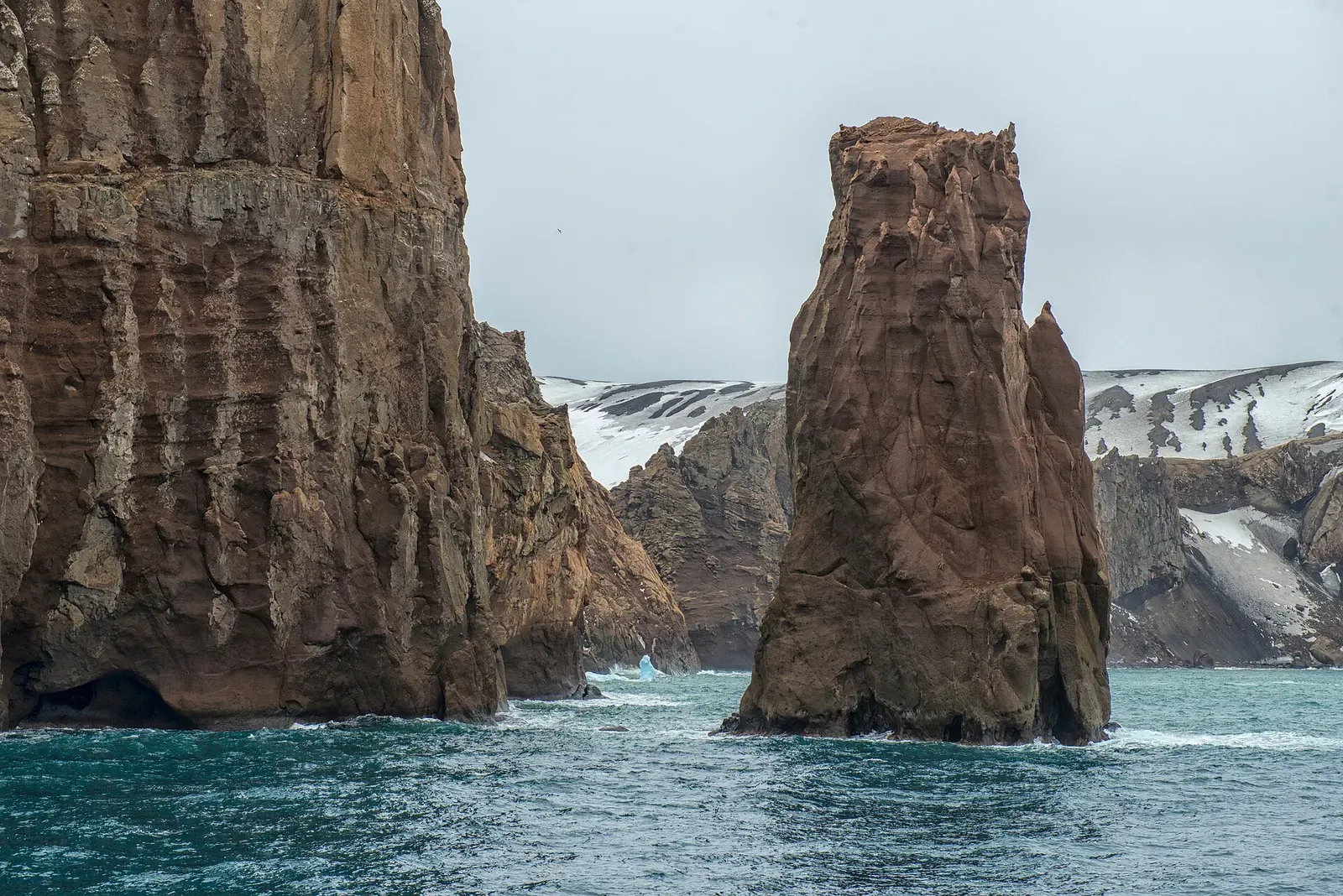 Weathered rock pillars rising from the sea at the entrance to Port Foster, Deception Island — Antarctic Peninsula