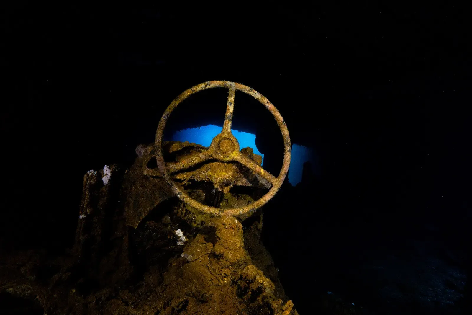 A ship's wheel silhouetted inside the Sankisan Maru — Chuuk Lagoon