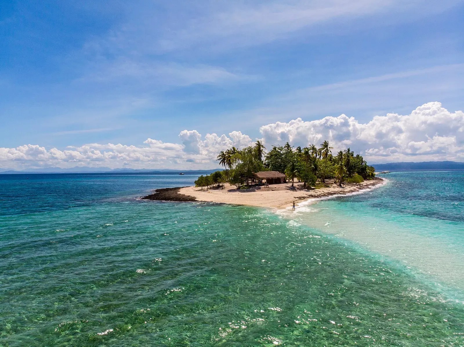 Aerial view of a small palm-covered island with a thatched hut and a white sandbar running into clear turquoise water — Kalanggaman Island, Malapascua