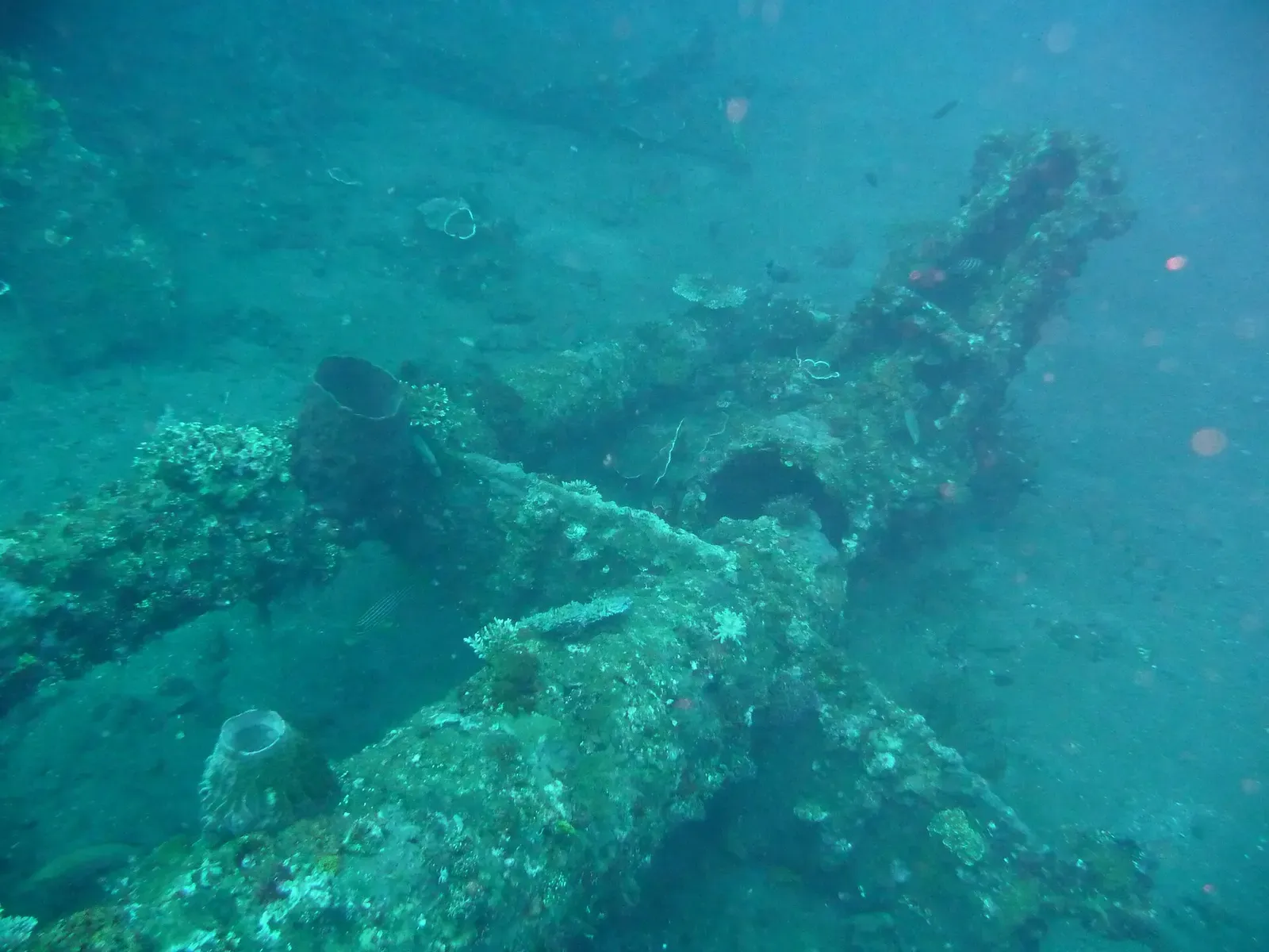 Submerged crane structure of the wreck resting on the sand slope in hazy blue water — USAT Liberty Wreck, Tulamben