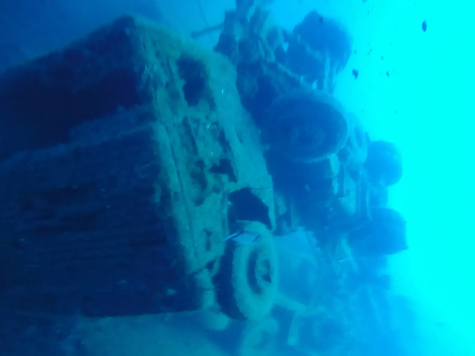 Close-up of an articulated truck's wheels and chassis resting on the Zenobia wreck