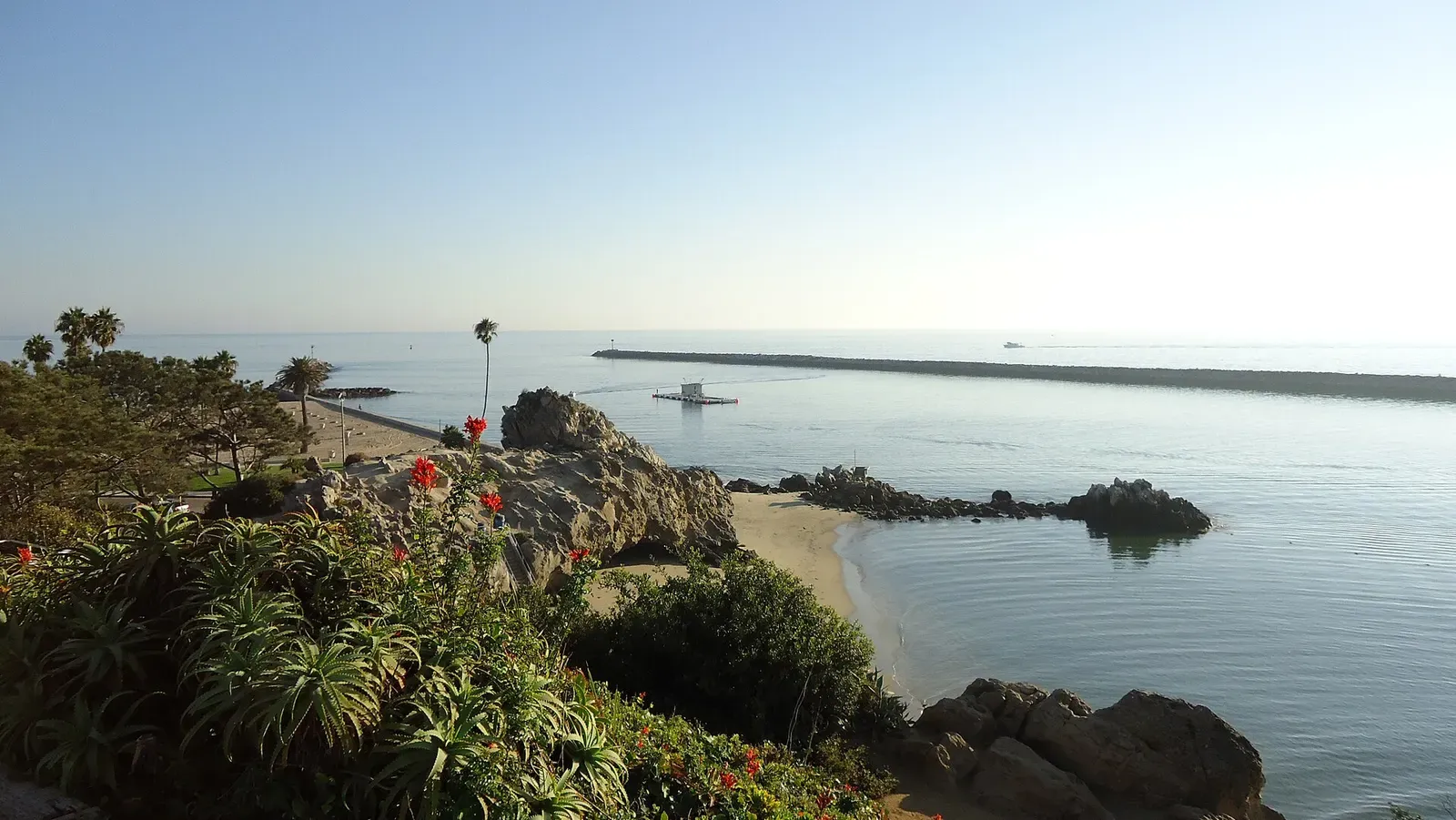View over a sheltered cove and rocks toward the Newport Harbor entrance jetty — Little Corona, Laguna Beach, Dana Point & Newport Beach