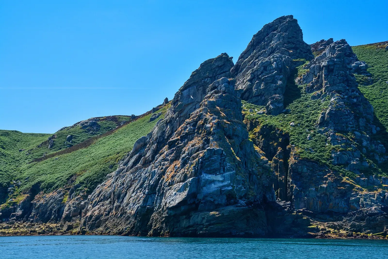 Rocky headland and pinnacle of Gannets Rock rising from the sea off Lundy's east coast — Lundy Island
