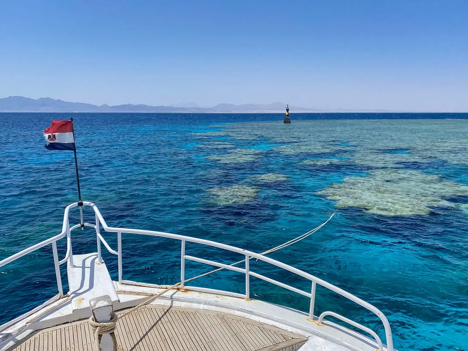 Dive boat bow approaching the reef at Middle Reef, Safaga, with a marker buoy ahead