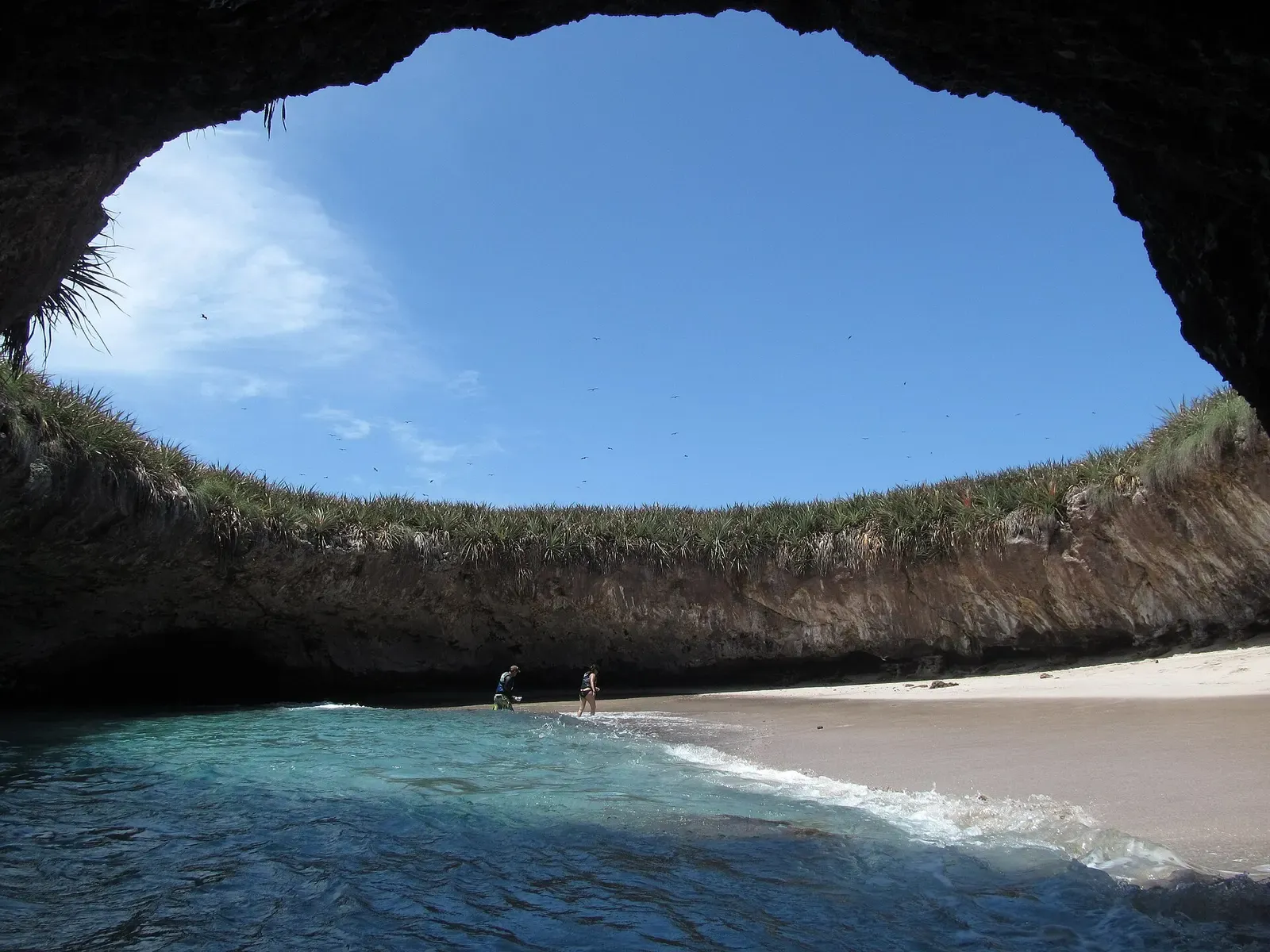 Looking out from inside a collapsed crater at a hidden sand beach ringed by rock and open to the sky — Islas Marietas, Puerto Vallarta & Banderas Bay