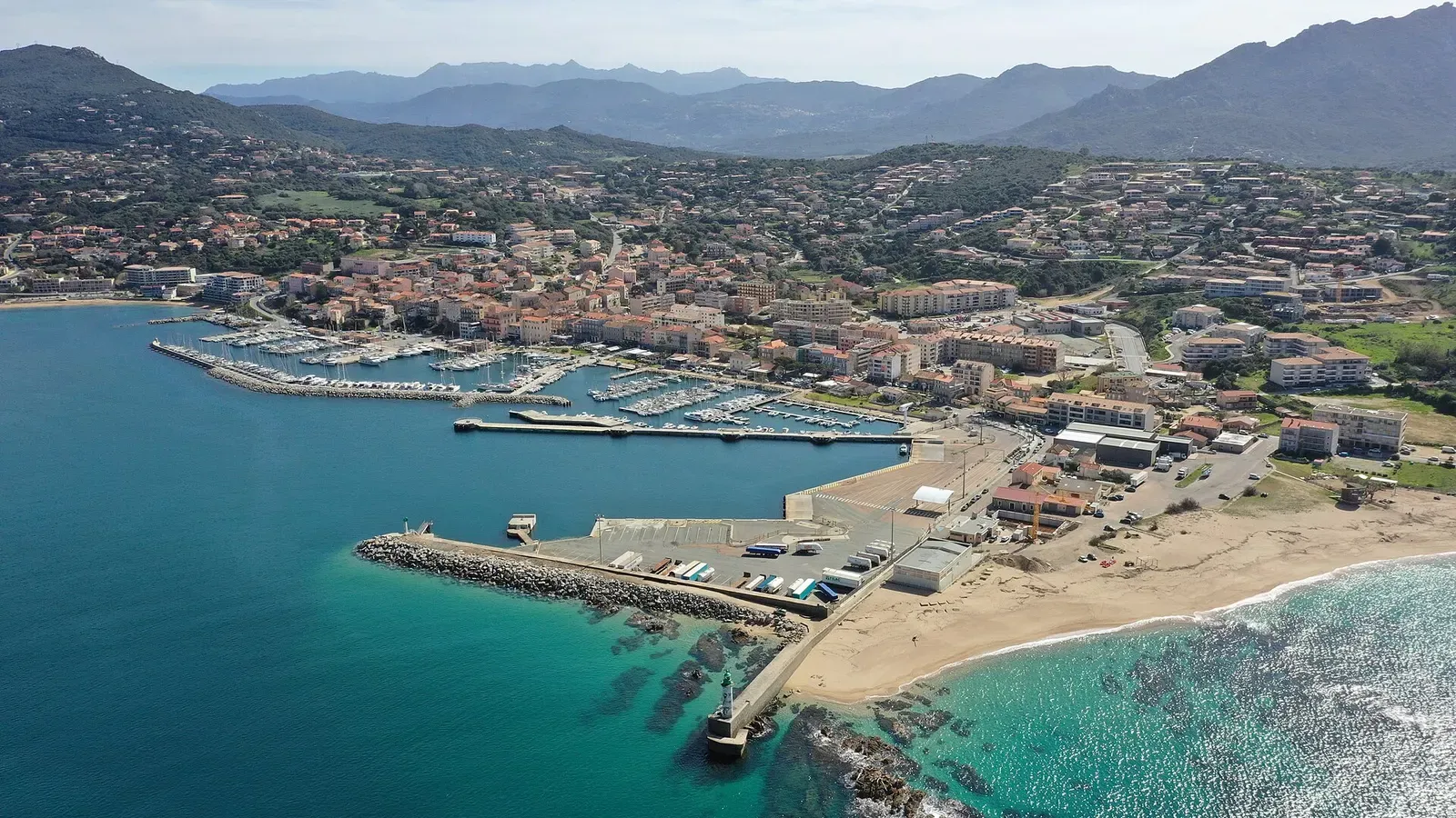 Aerial view of Propriano's marina, breakwater and turquoise coastal water, Corsica.