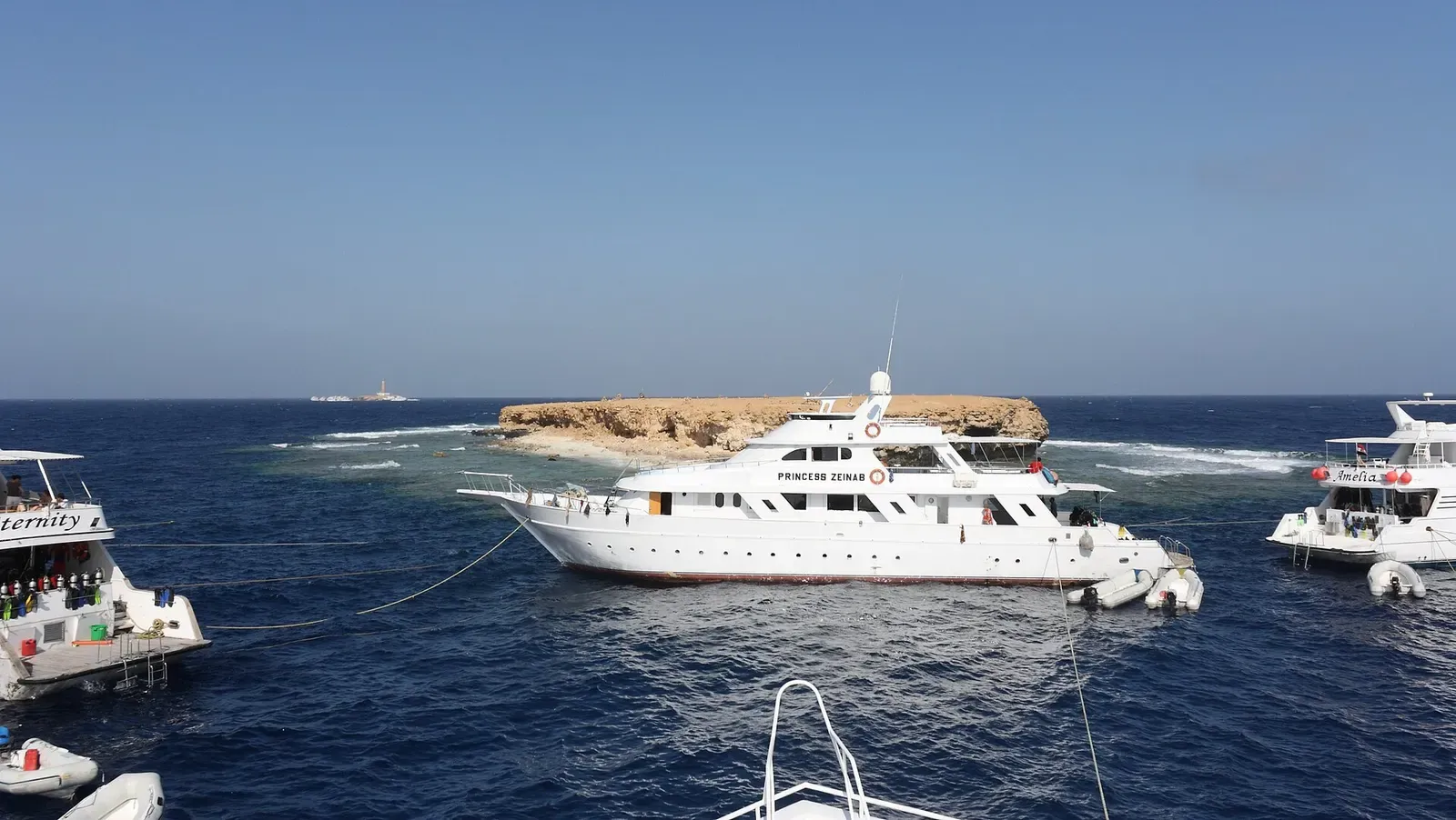 Liveaboard dive boats anchored beside the low rocky islet of Little Brother — Little Brother Island, Brothers & Daedalus