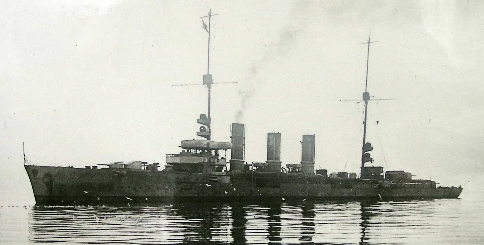 Black-and-white photo of the three-funnelled light cruiser SMS Dresden underway at sea — Scapa Flow.