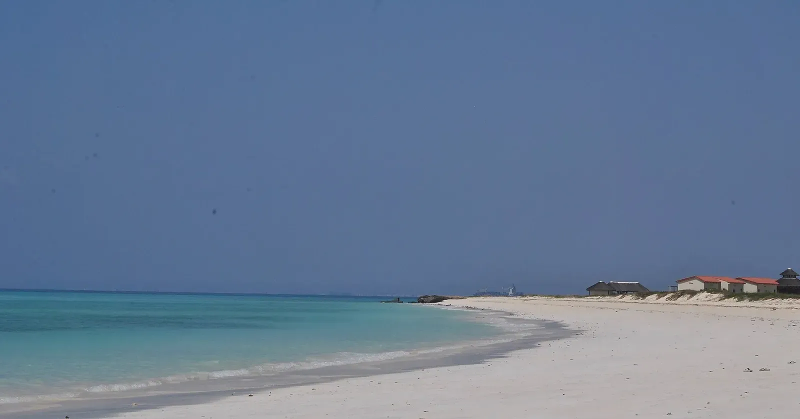 Empty white sand beach on Moucha Island against emerald shallows — Djibouti