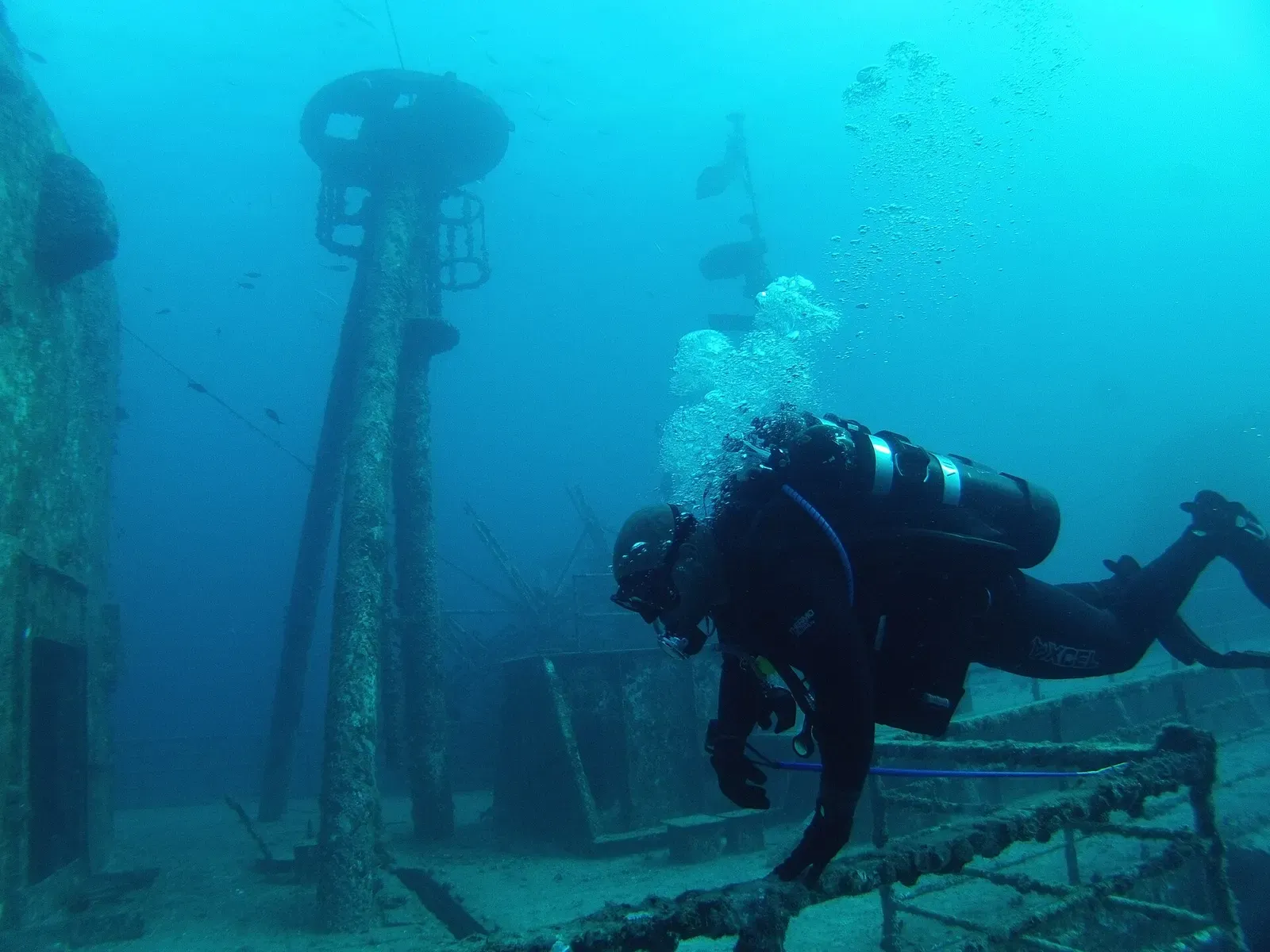 Diver hovering beside the wreck's mast and rigging