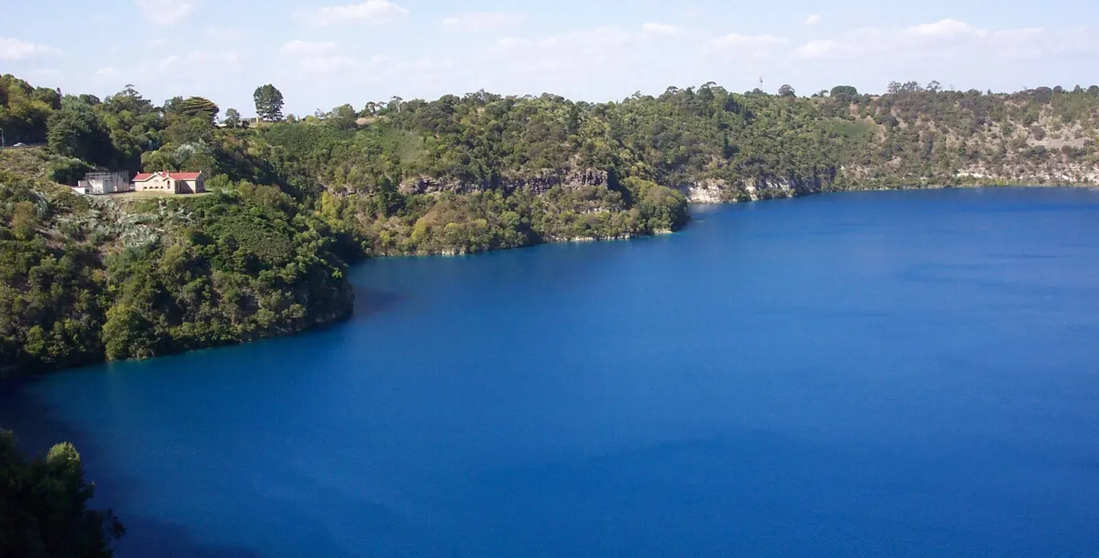 Blue Lake filling its crater with steep bush-covered slopes around it