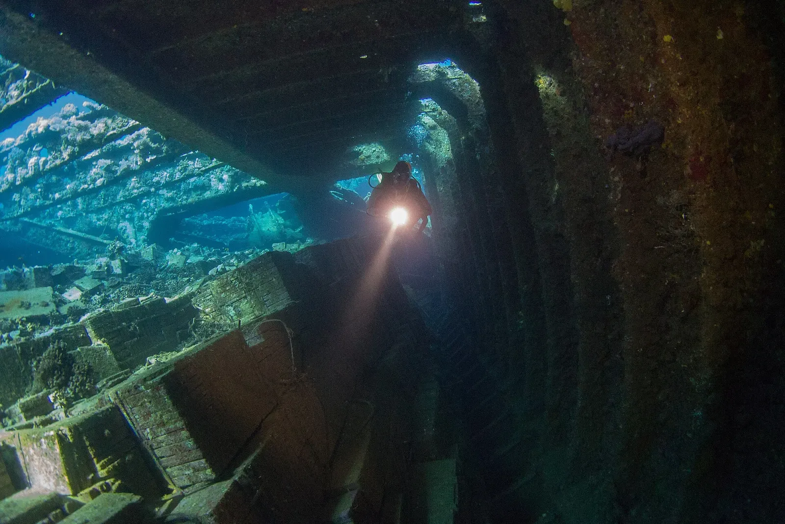 A diver's torch lights the cargo deck inside the wreck of the Chrisoula K — Abu Nuhas