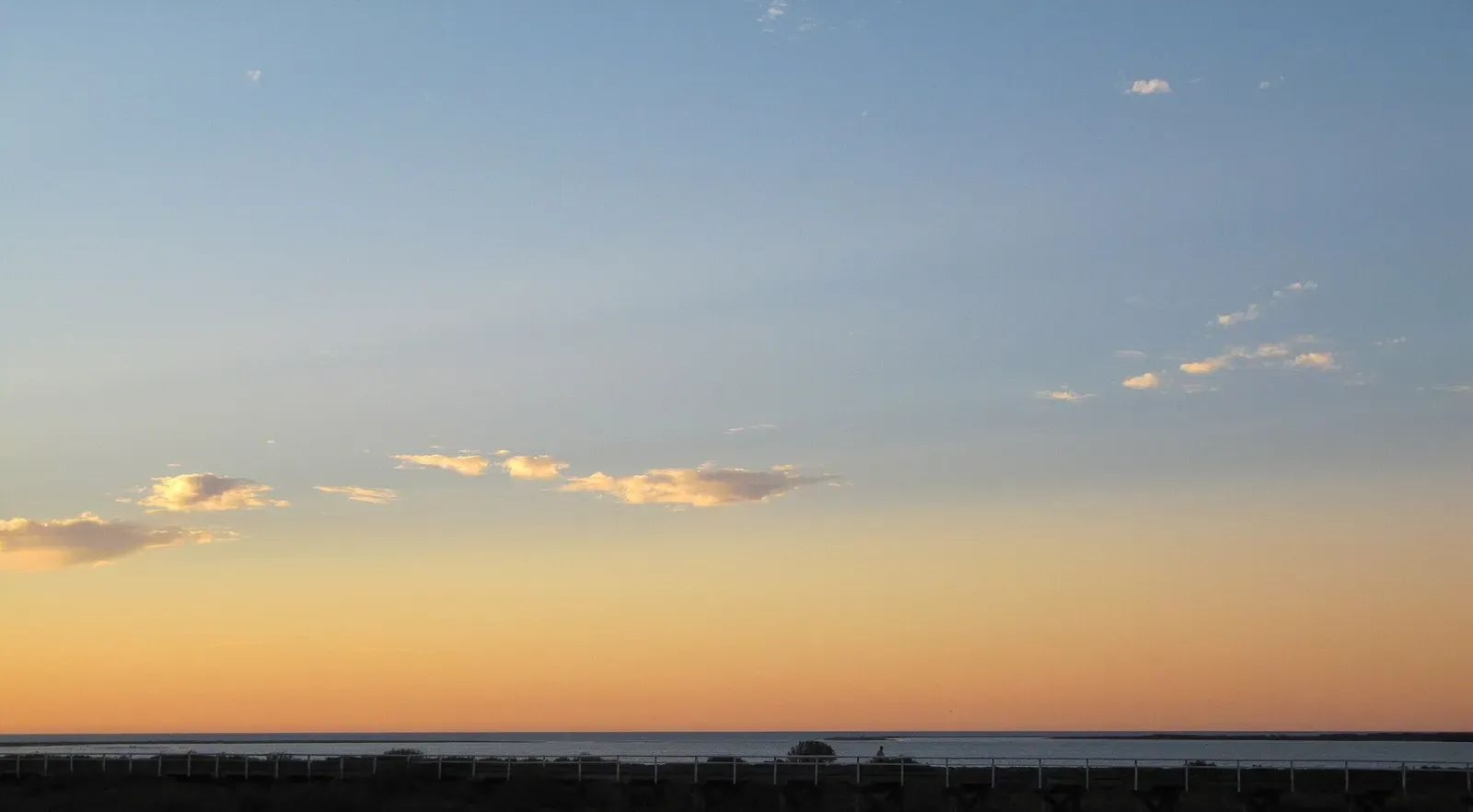 Sunset clouds over the sand and water at Coral Beach — Coral Bay, Ningaloo Reef.