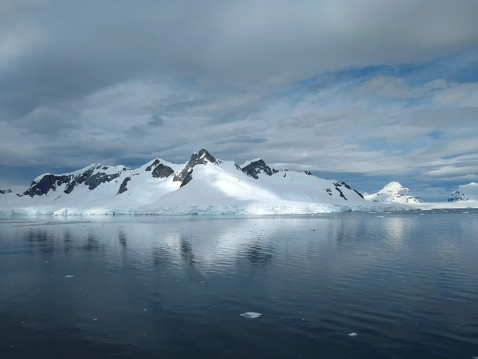 A twin-peaked mountain rising above the glacier-lined shore of Paradise Bay — Paradise Harbour, Antarctic Peninsula