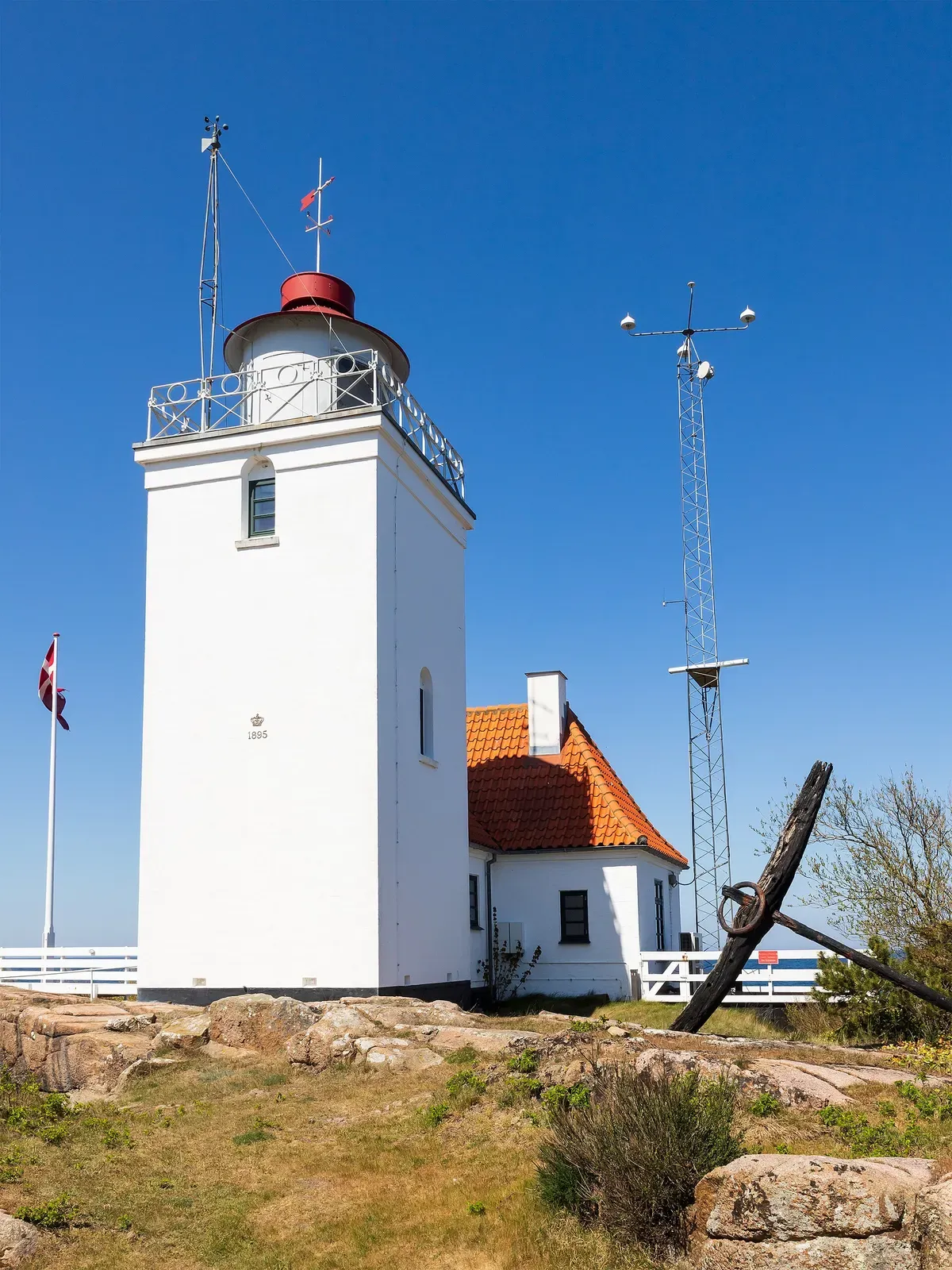 Hammerodde Fyr with a ship's anchor and radio mast on the headland below — Hammeren, Bornholm.
