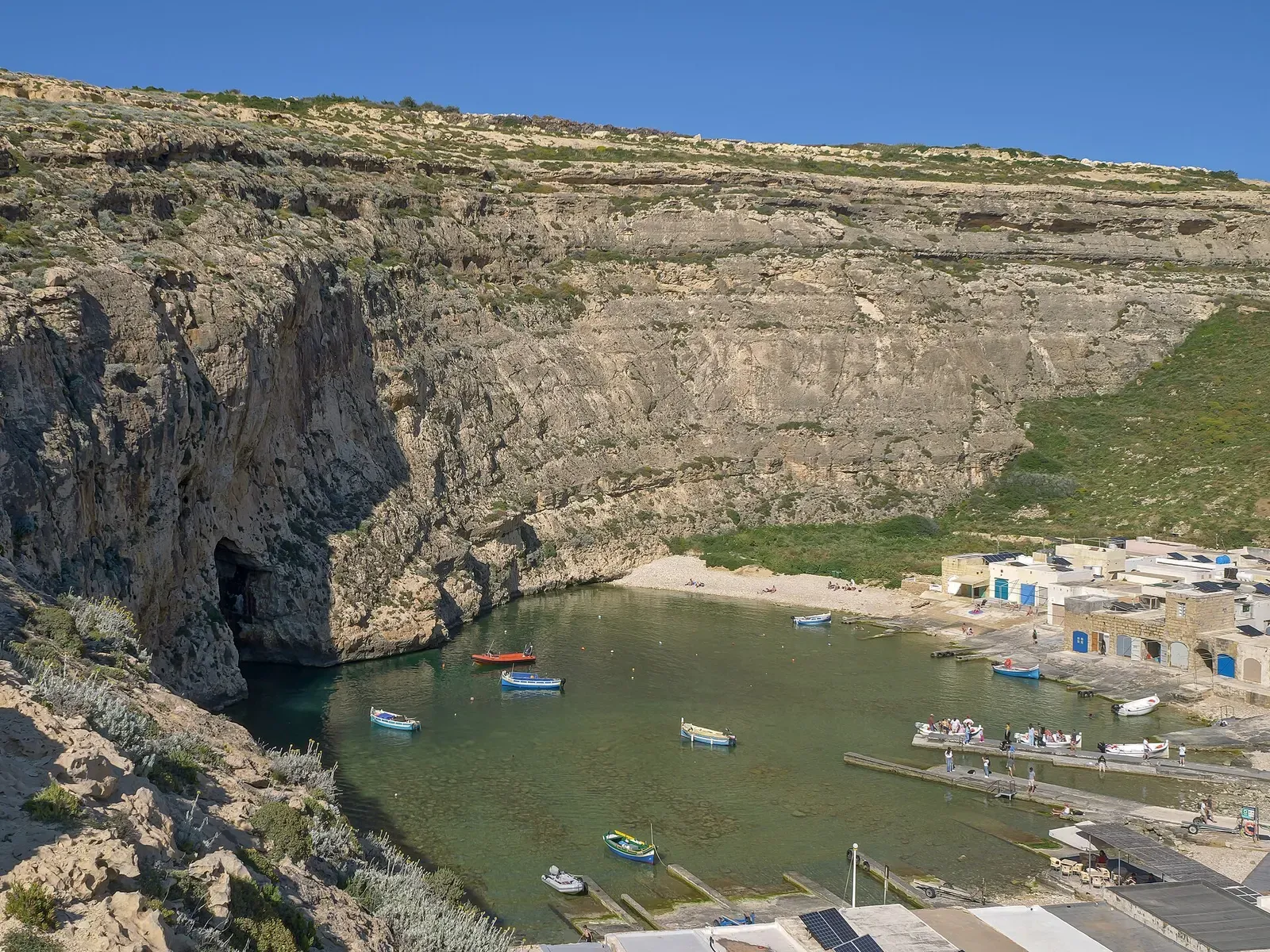 Aerial view of the enclosed Inland Sea lagoon at Dwejra with small dive boats moored inside the cliff-ringed bay — Gozo & Malta