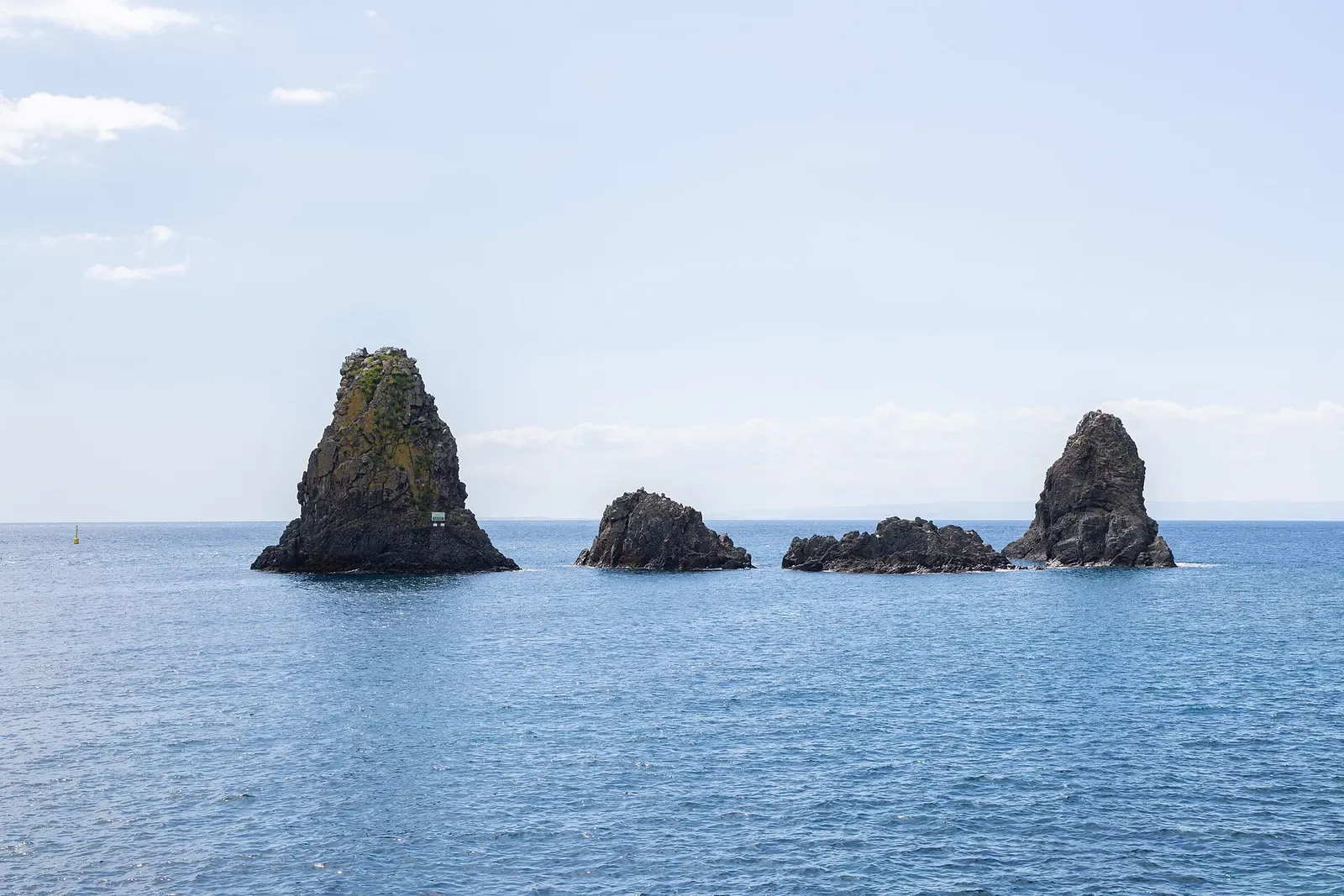 Two smaller Cyclops sea stacks with calm water between them, seen from the coast