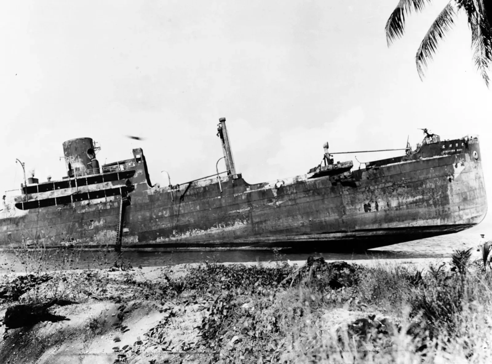 The rusting hull of Kinugawa Maru beached on Guadalcanal's shore, photographed a year after it sank — Bonegi II, Iron Bottom Sound
