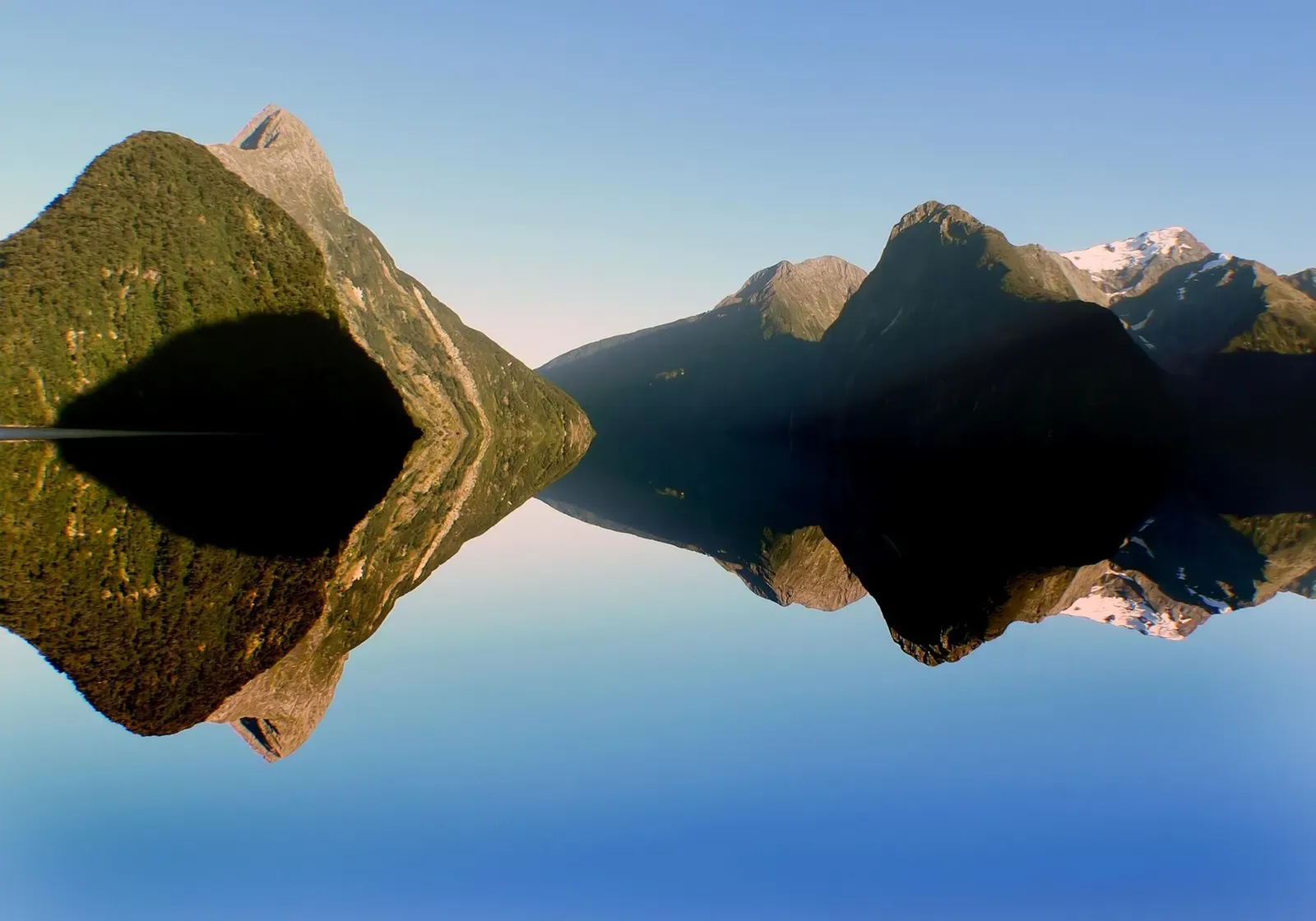 Symmetrical dusk view of Mitre Peak mirrored in the calm sound — Milford Sound (Piopiotahi), Fiordland