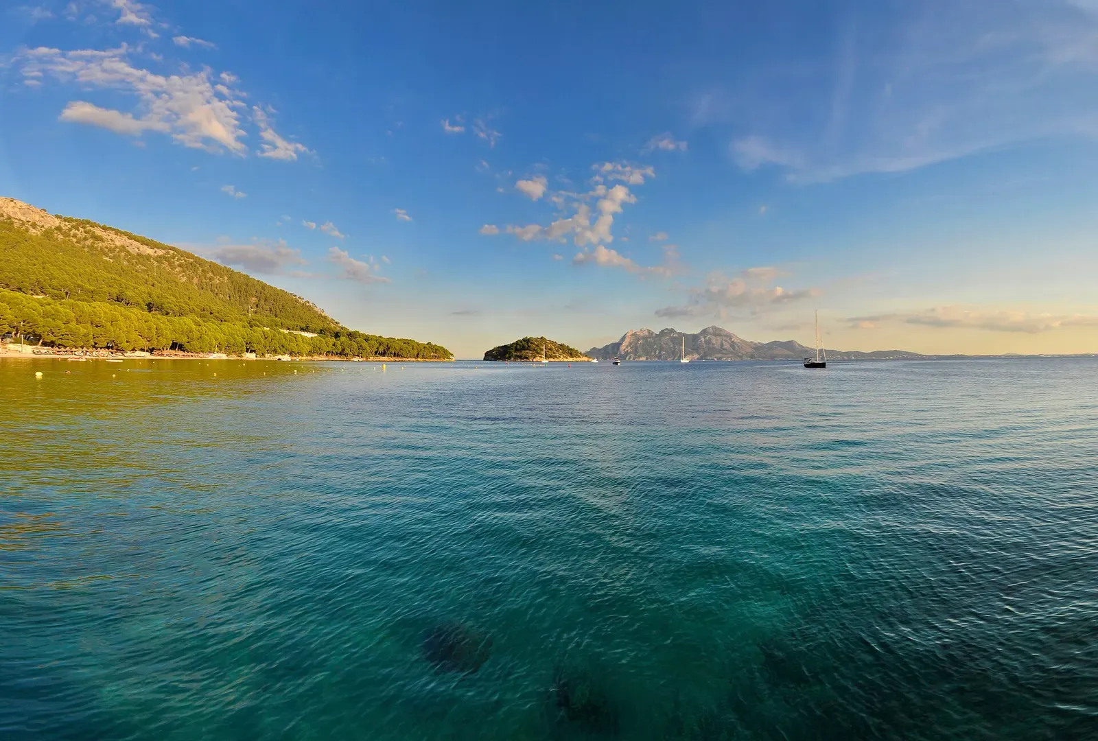 Panoramic bay view with sailboats anchored near the Formentor islet