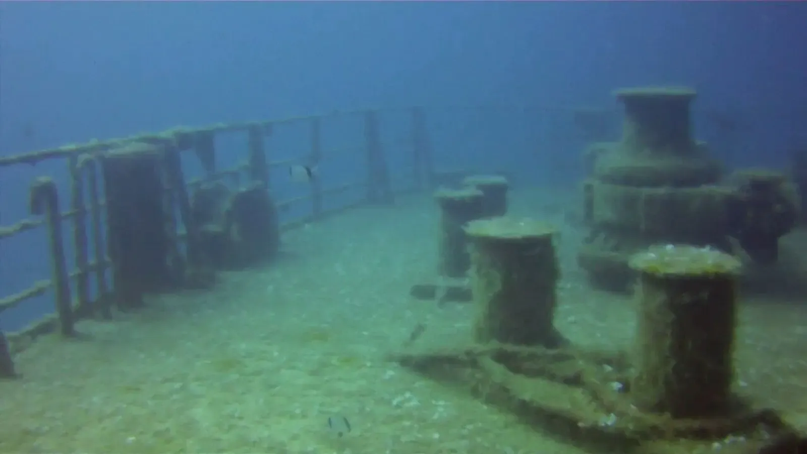 The stern deck rail and bollards of the Um El Faroud wreck seen through green water — Gozo & Malta