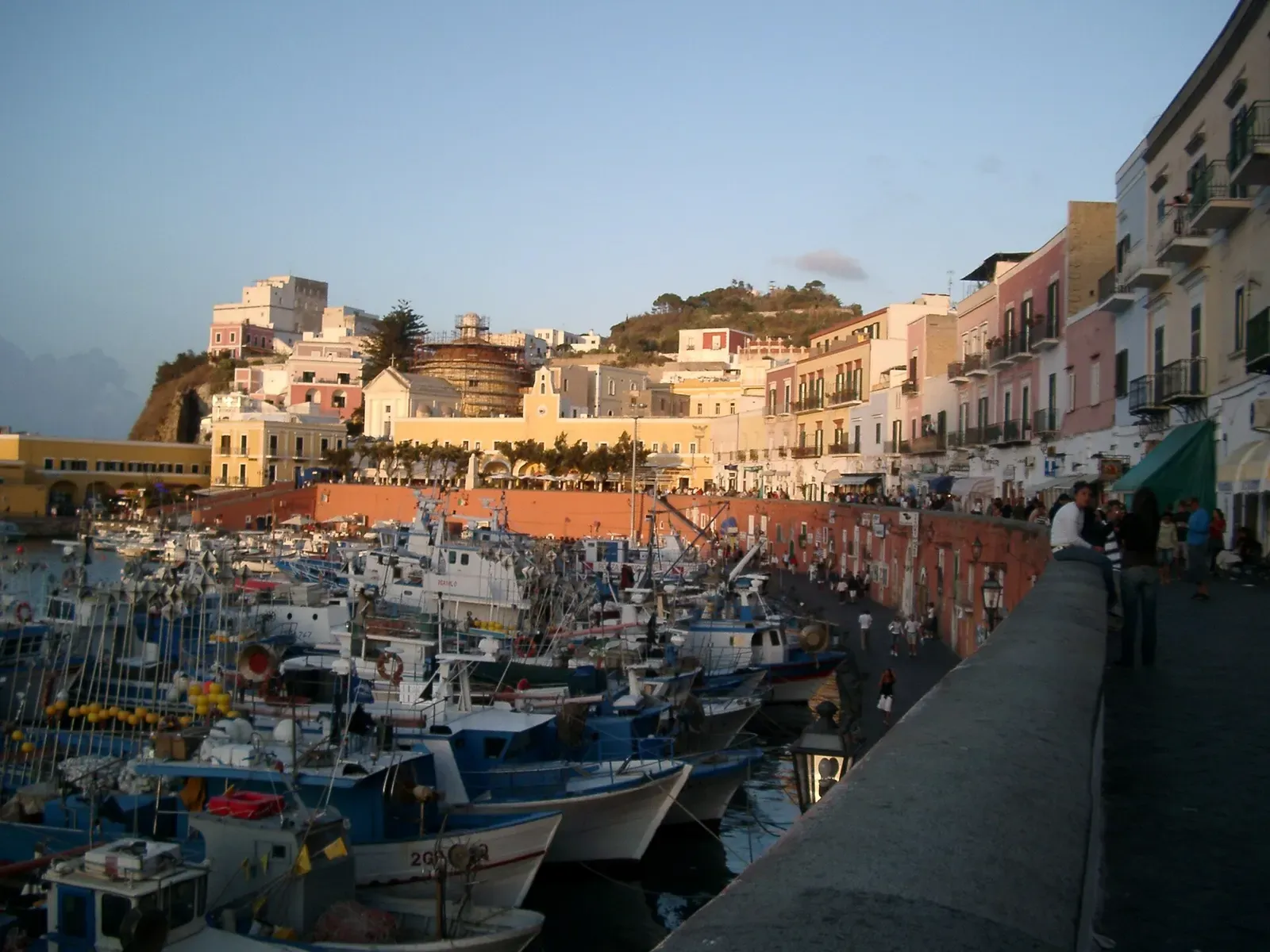 Fishing boats moored along the pastel waterfront buildings of Ponza's harbour