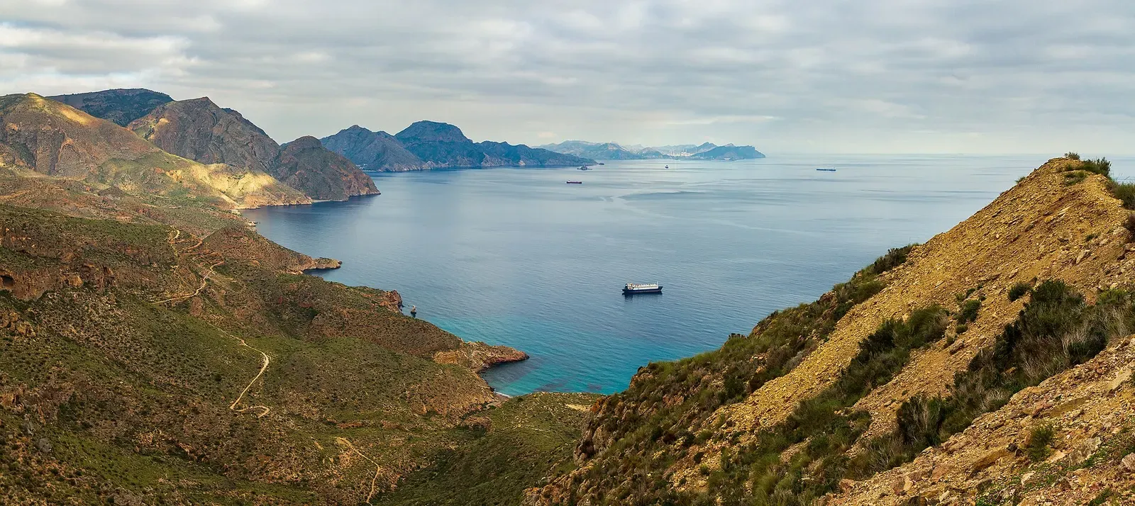 Aerial view of a rocky cove and headland where mountains meet the Mediterranean near Cartagena.