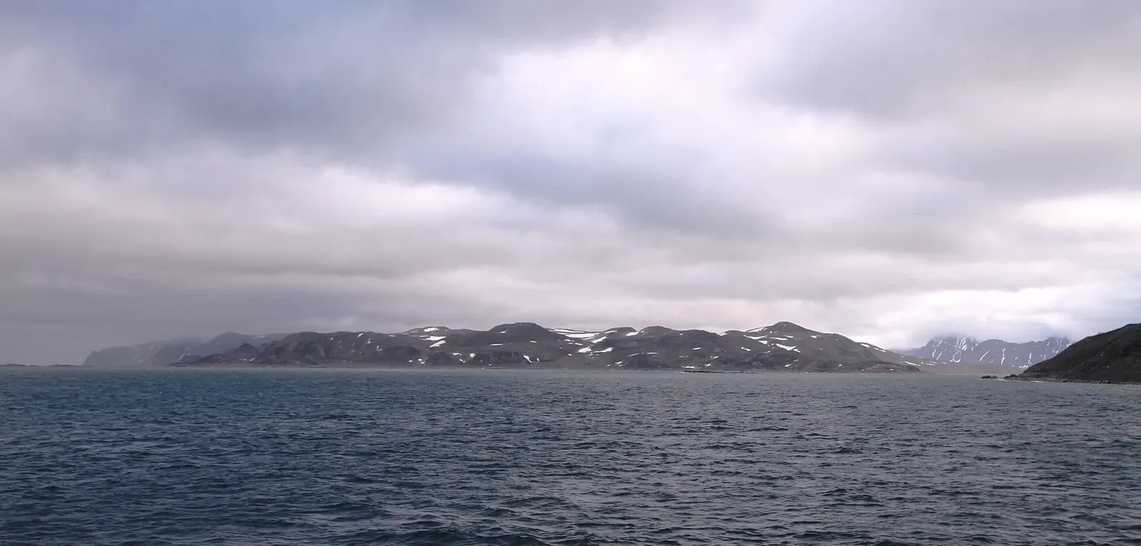 Overcast view of Danskøya's coastline from the south, at the mouth of Smeerenburgfjorden — Svalbard.