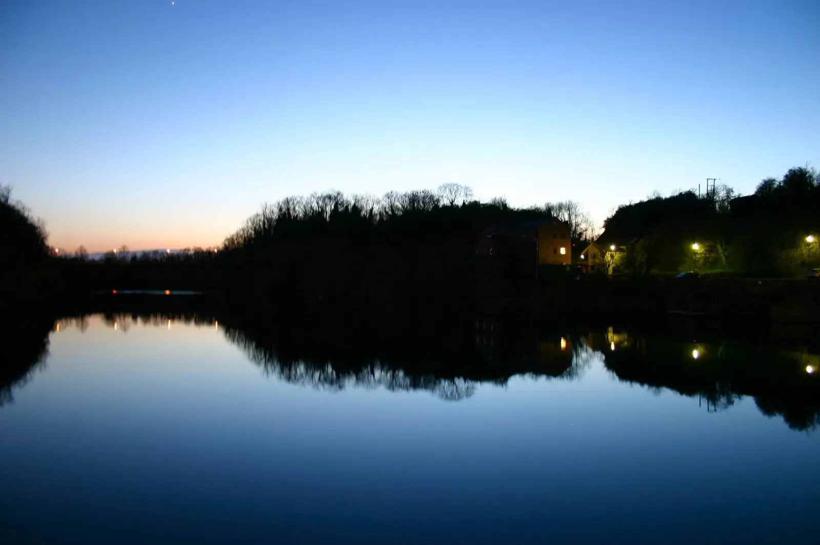 The quarry at dusk with the dive centre lit up on the far bank