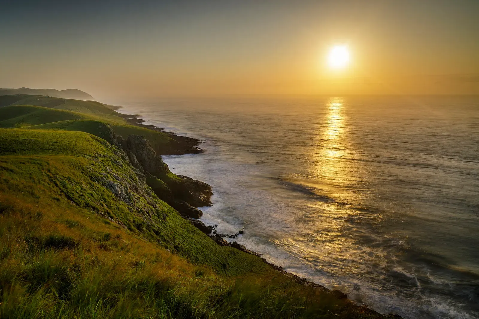 Sunrise over rugged green cliffs and open ocean along the Wild Coast near Port St Johns — Sardine Run.