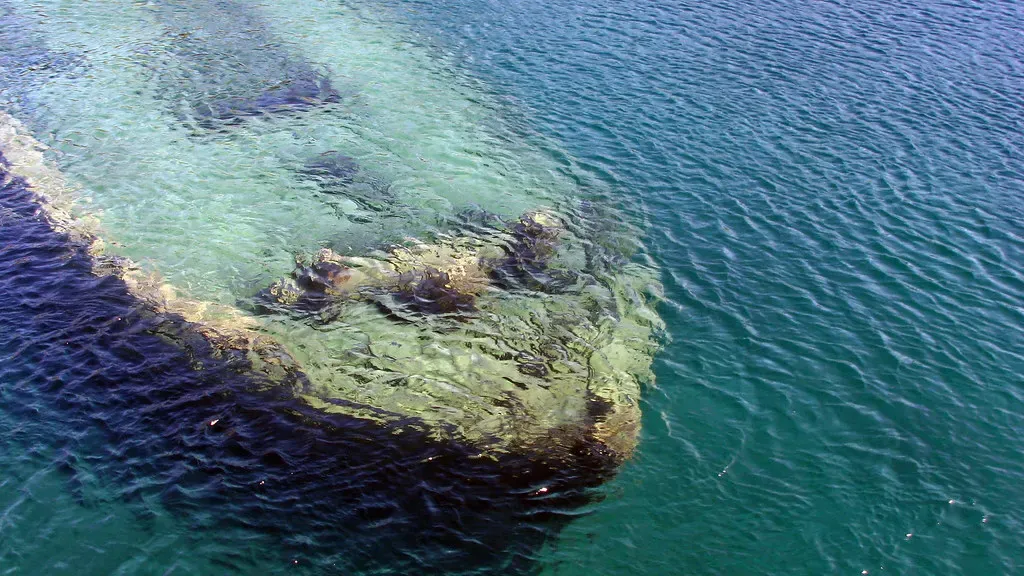 Weathered wreck timbers breaking the water's surface at the wreck's bow — Sweepstakes, Tobermory