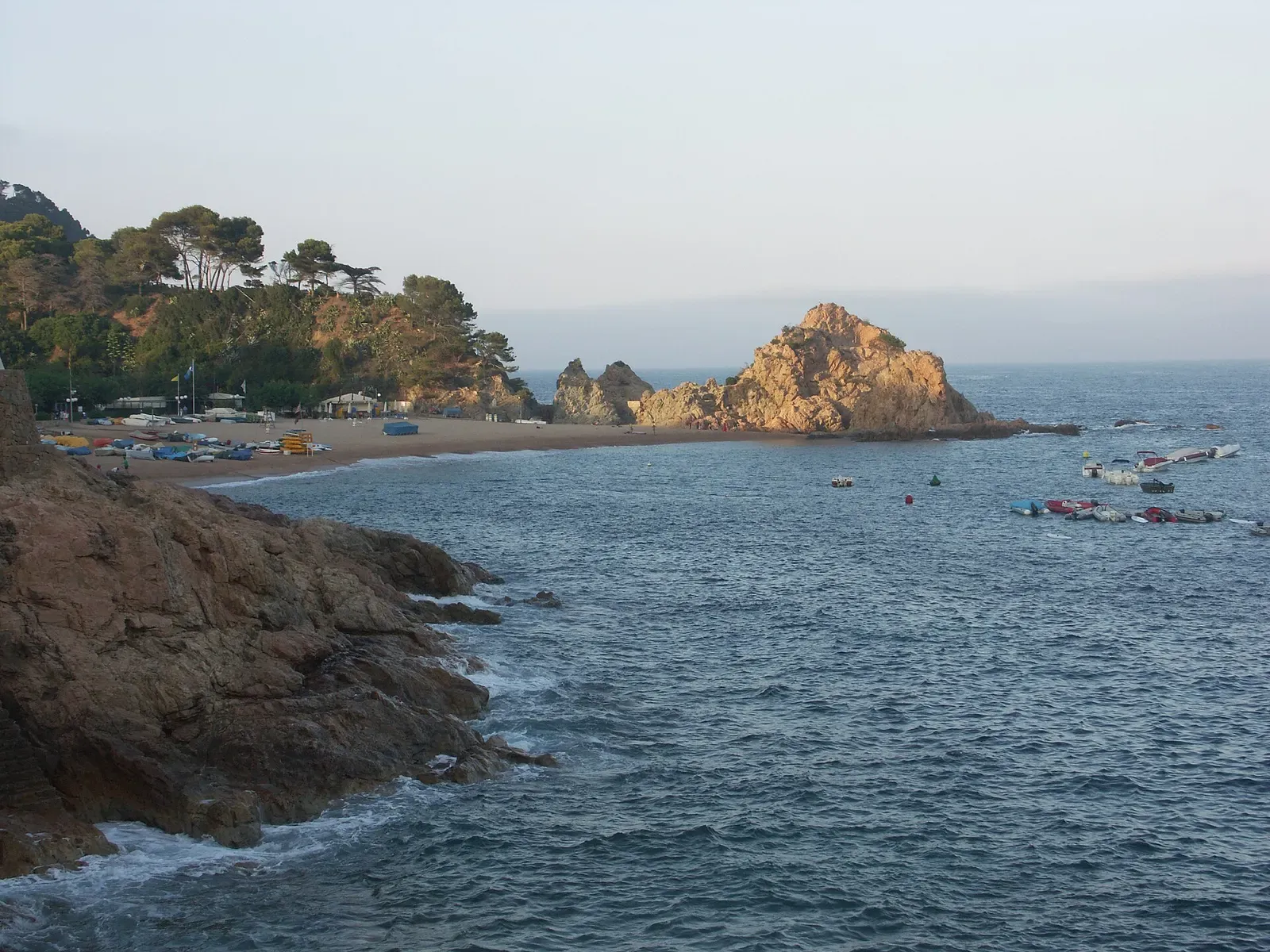 Wide view of Mar Menuda beach and its rocky headland at Tossa de Mar.