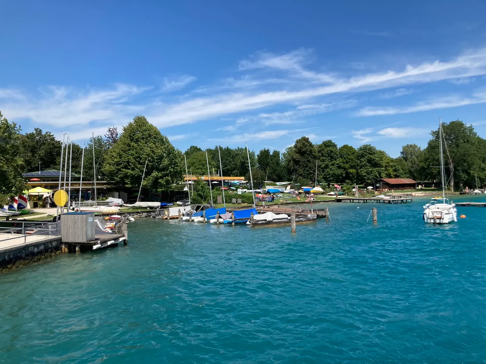 Small boats and jetties along the shallow turquoise shore at Nussdorf