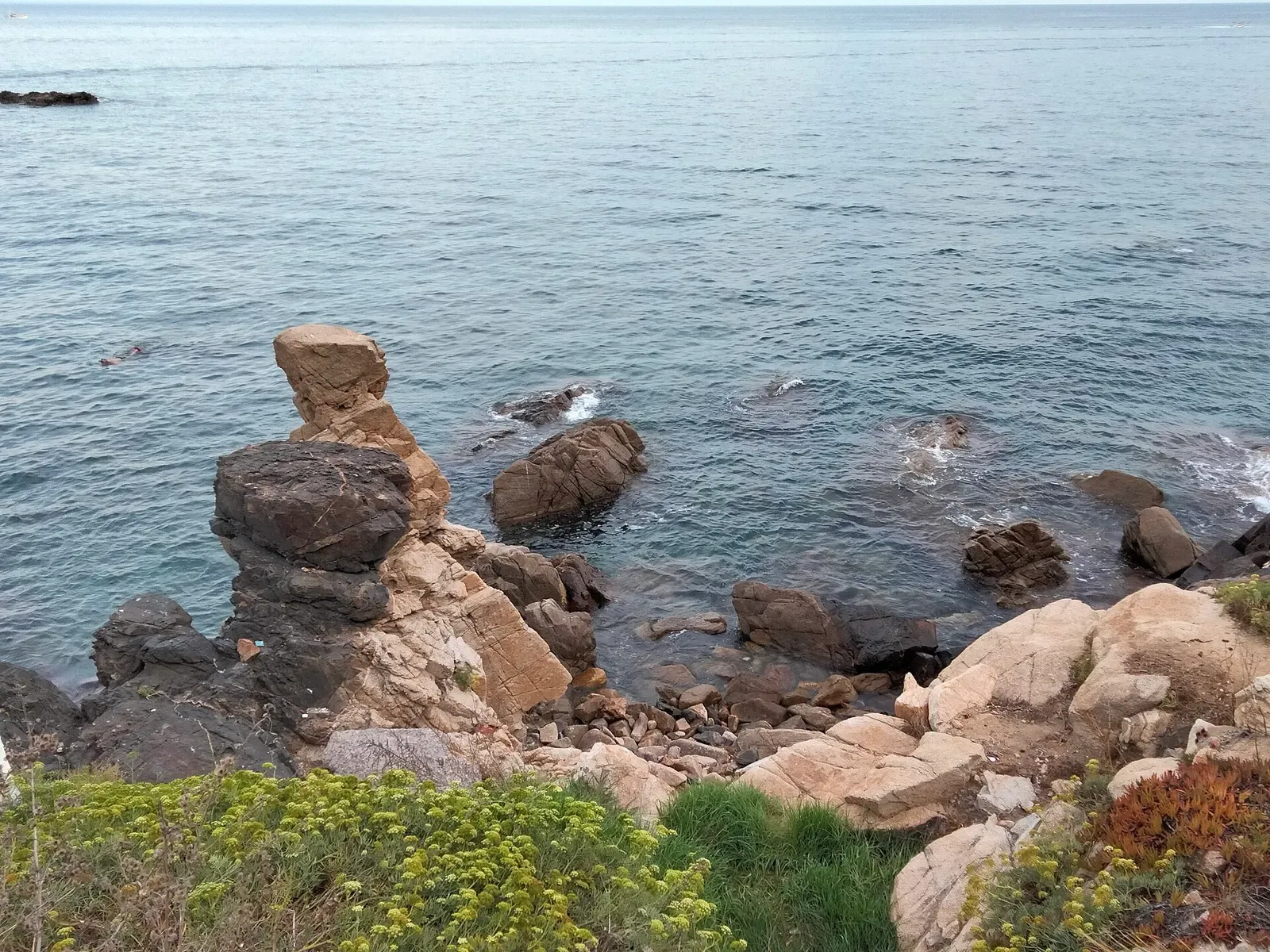 Low rocky reef breaking the surface beside Cala Margarida