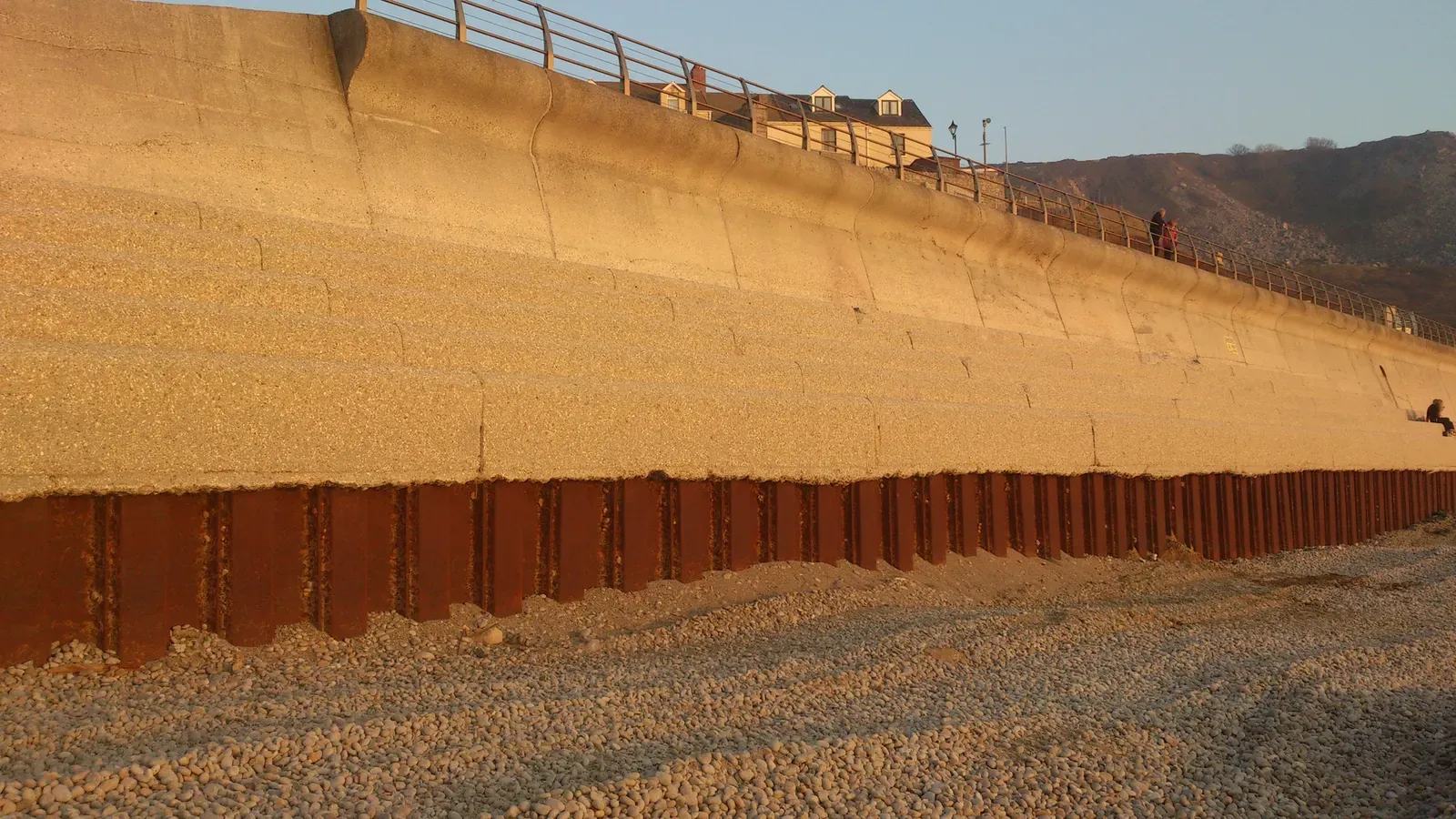 Layered timber and stone flood-defence steps on the beach at Chesil Cove