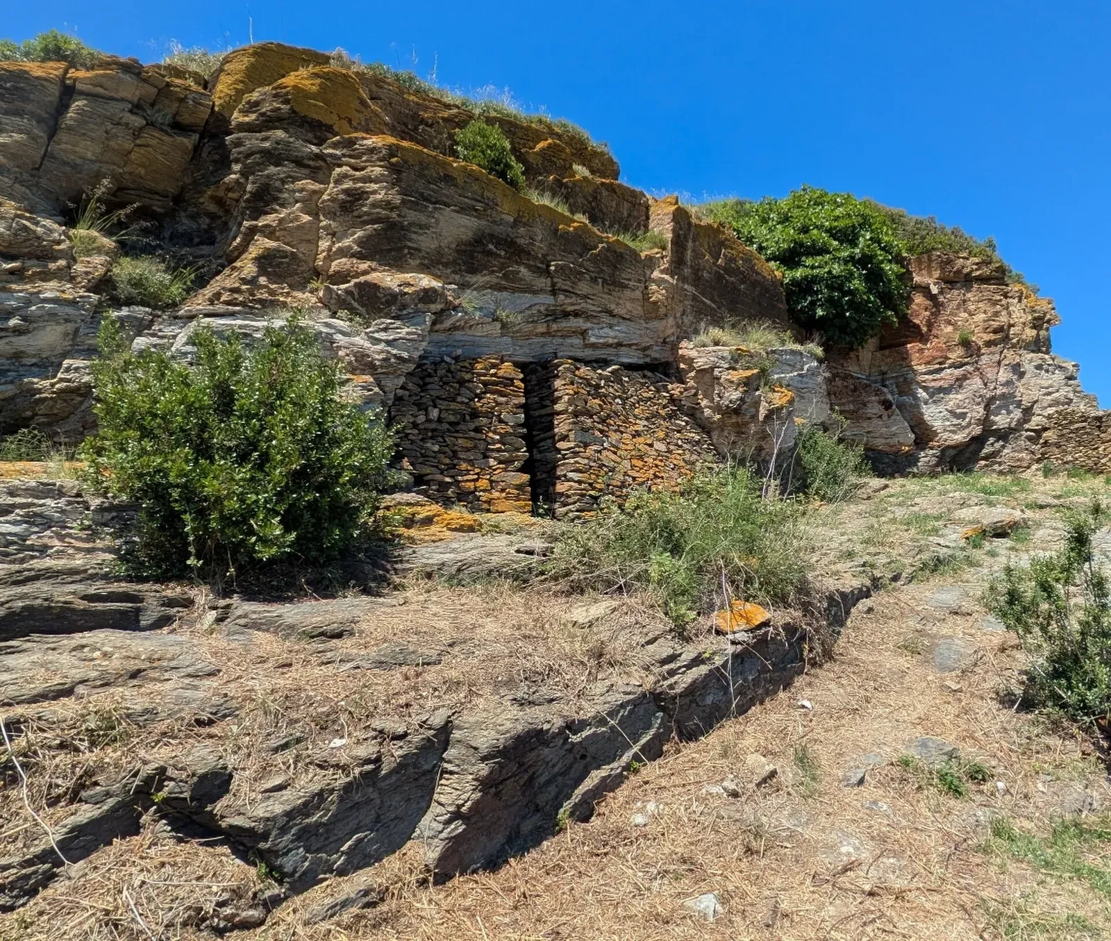 Entrance to the Cova de les Ermites, a natural limestone cave cut into the cliff at Cap Norfeu — Cap de Norfeu, Cap de Creus