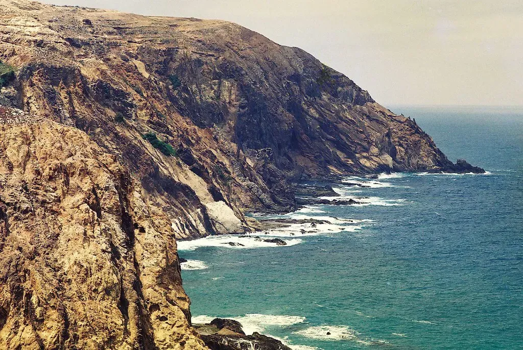 Steep rocky cliffs along the north coast of Porto Santo with waves breaking at their base
