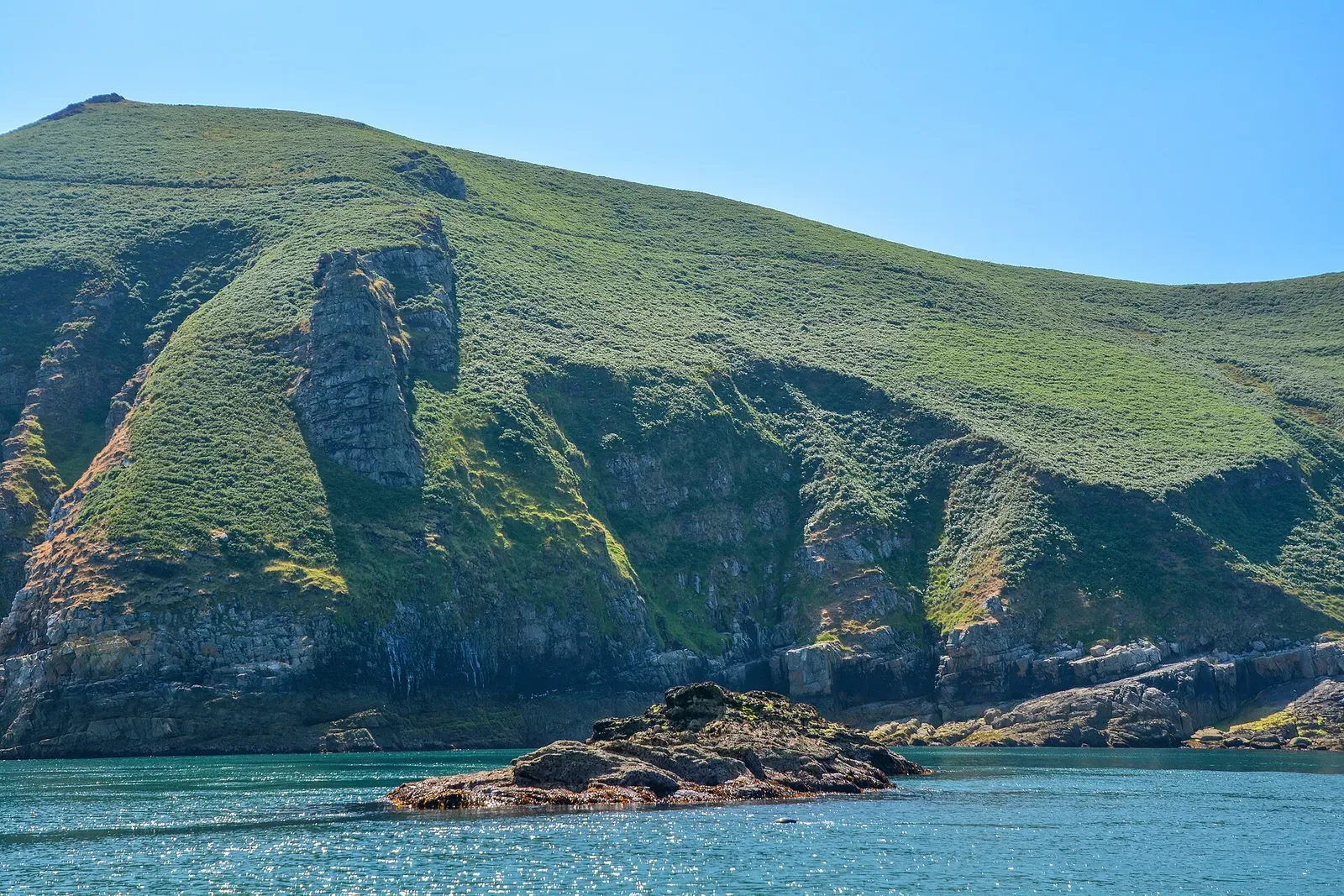 Green cliffs and small rocky islet near the Knoll Pins dive site, Lundy — Lundy Island
