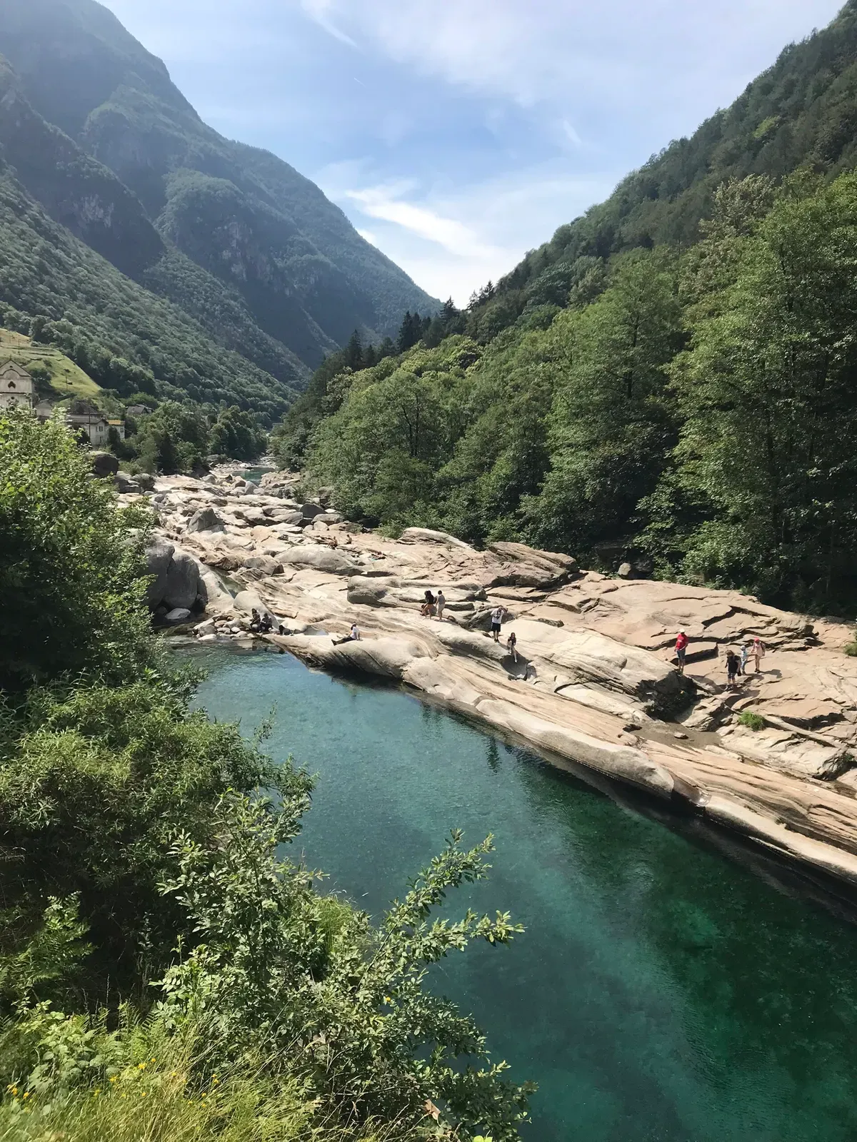 Aerial view of a deep emerald pool in the Verzasca river bordered by pale granite slabs — Verzasca Valley