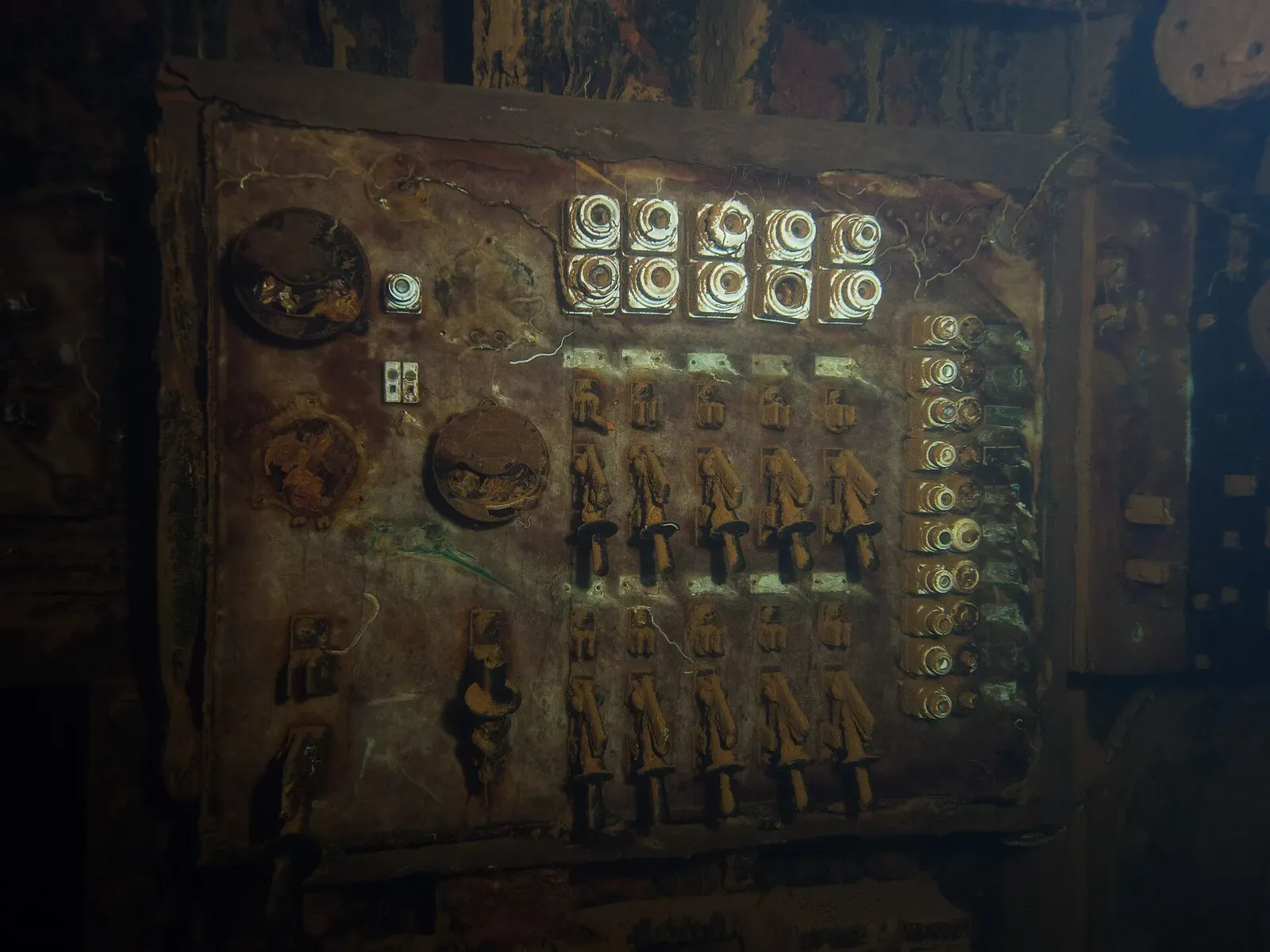 Rusted electrical switchboard with rows of fuses and breakers inside a wreck engine room — Sudanese Red Sea