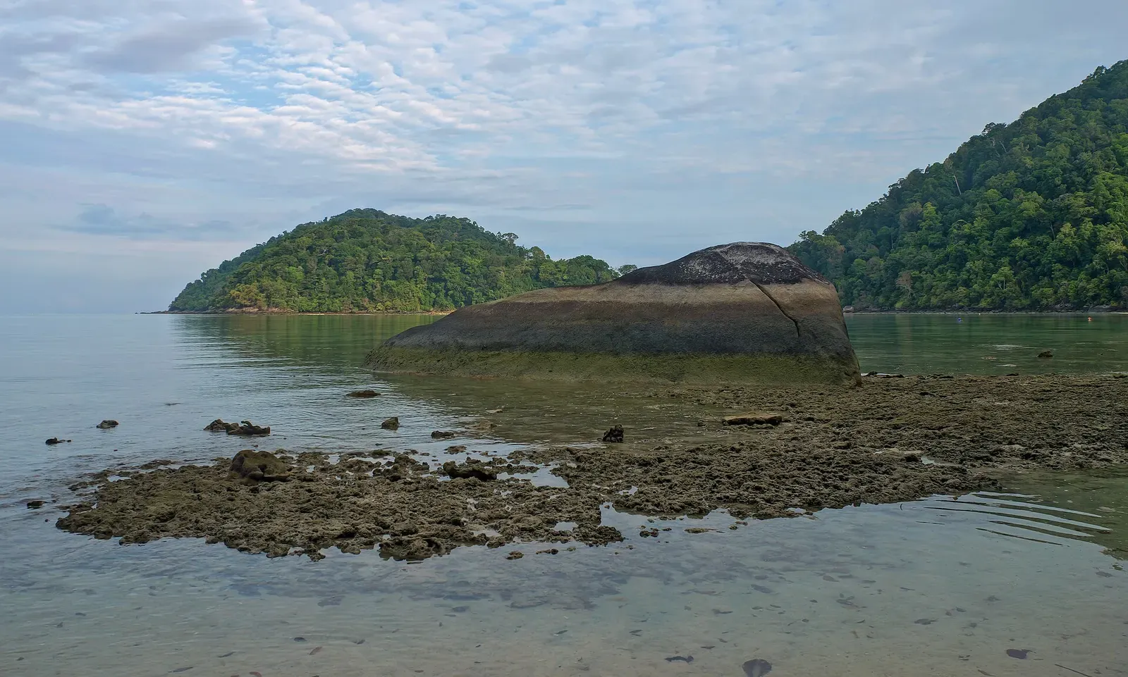 A large granite boulder rests on an exposed reef flat at low tide, North Surin Island — Surin Islands
