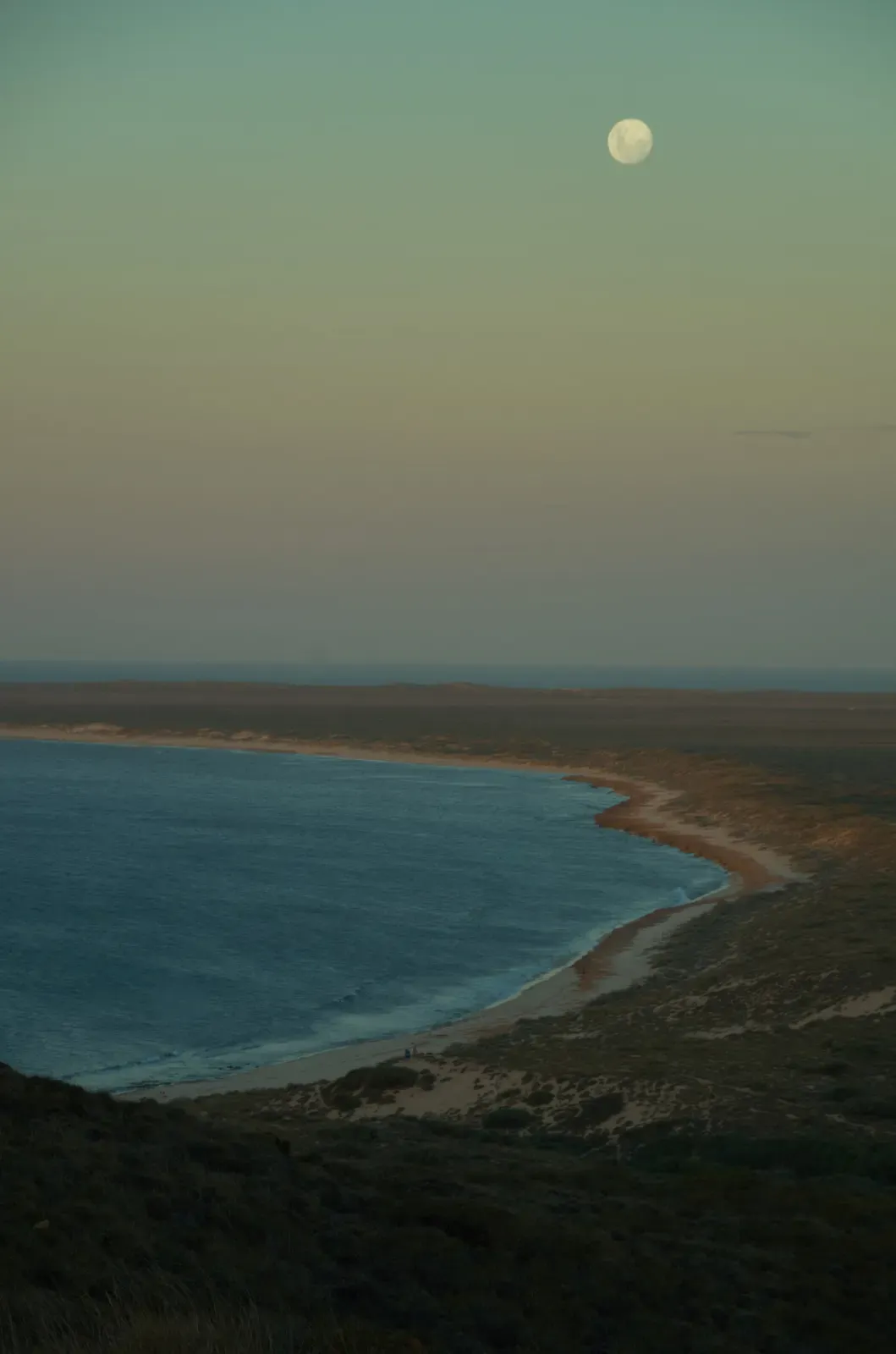 Full moon rising over a curved bay on North West Cape, seen from Vlamingh Head near Exmouth — Exmouth Navy Pier