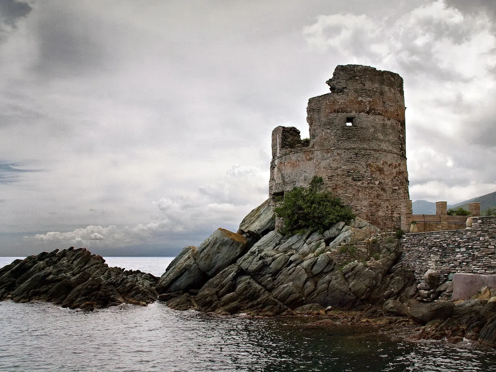 Genoese watchtower standing on a rocky point in the sea at Erbalunga