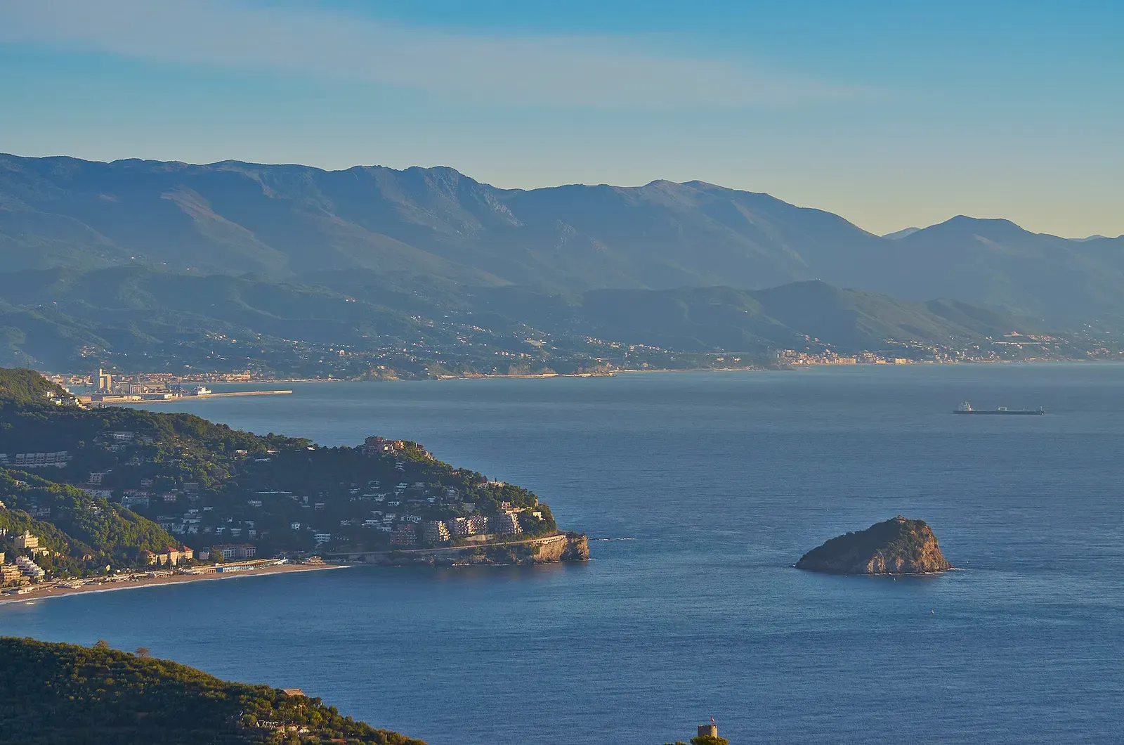 View along the Ligurian coast from Torre del Mare, with Isola di Bergeggi visible offshore in the distance