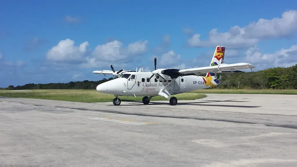 A Cayman Airways Express twin-engine propeller plane on the Little Cayman airstrip